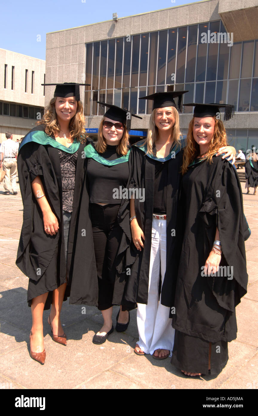 Group of four young women students graduates graduating in caps and ...