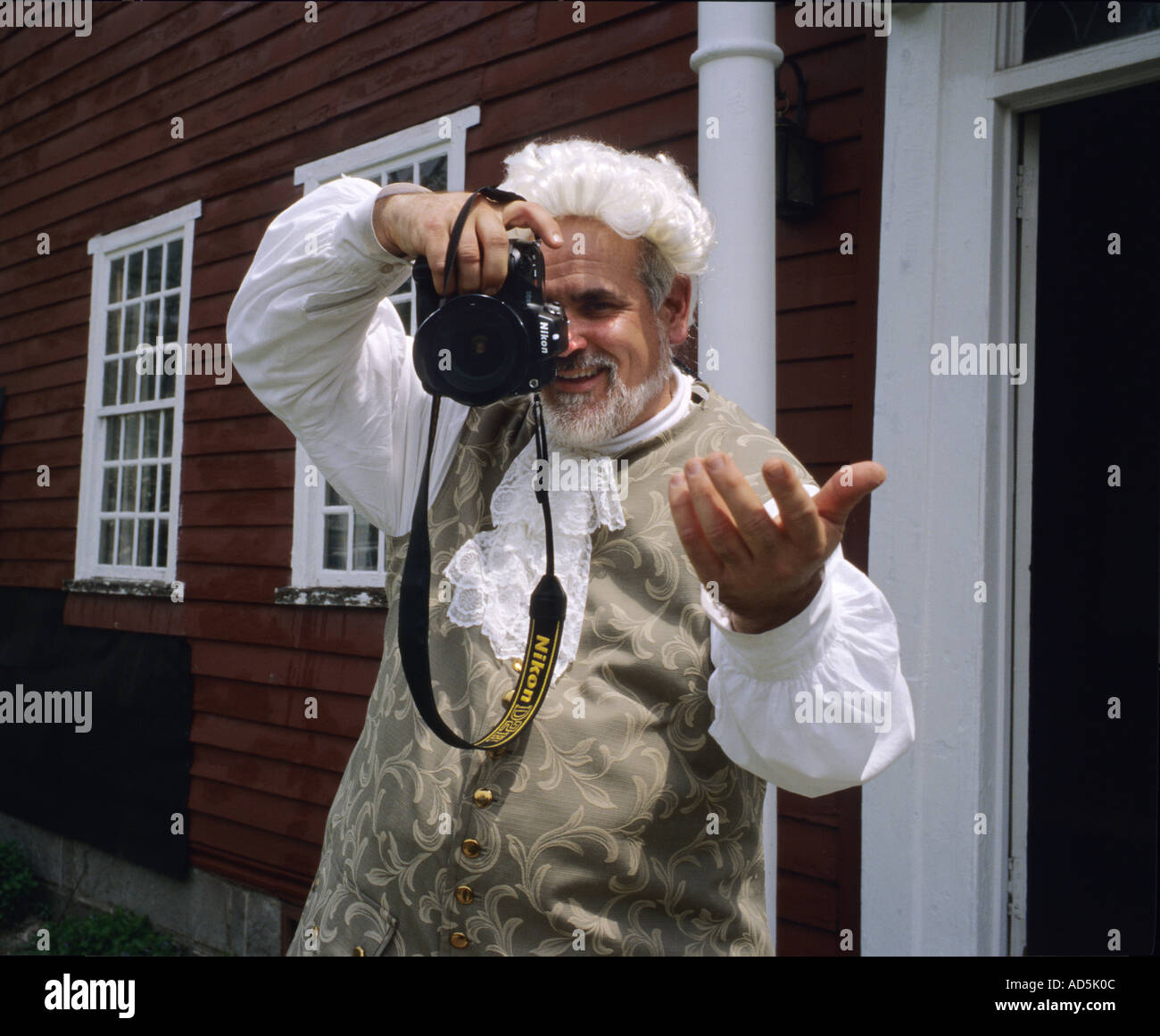 Man dressed in colonial era clothing using a modern camera Stock Photo