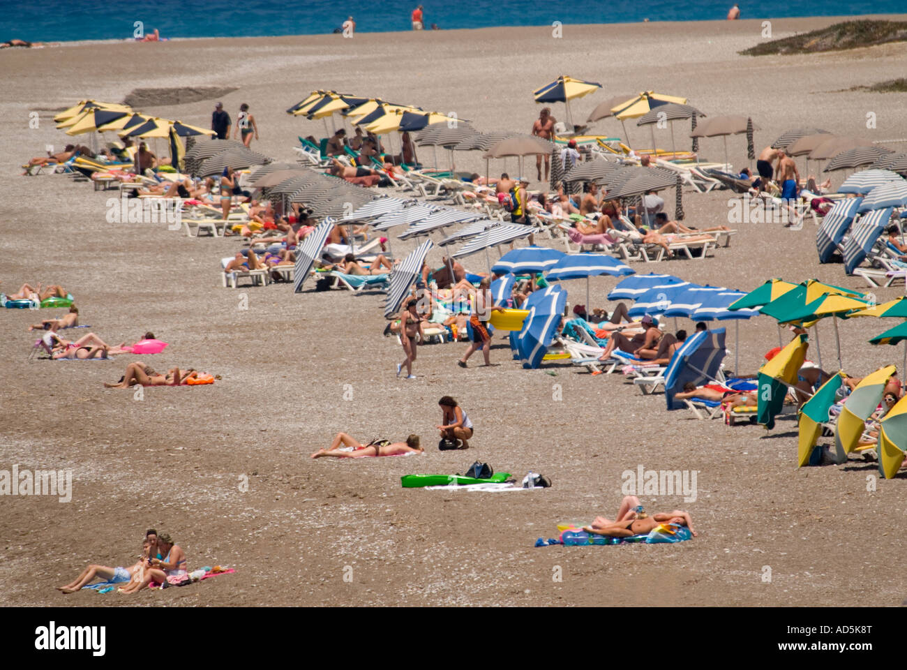 Horizontal aerial view of people enjoying themselves sunbathing on the beach. Stock Photo