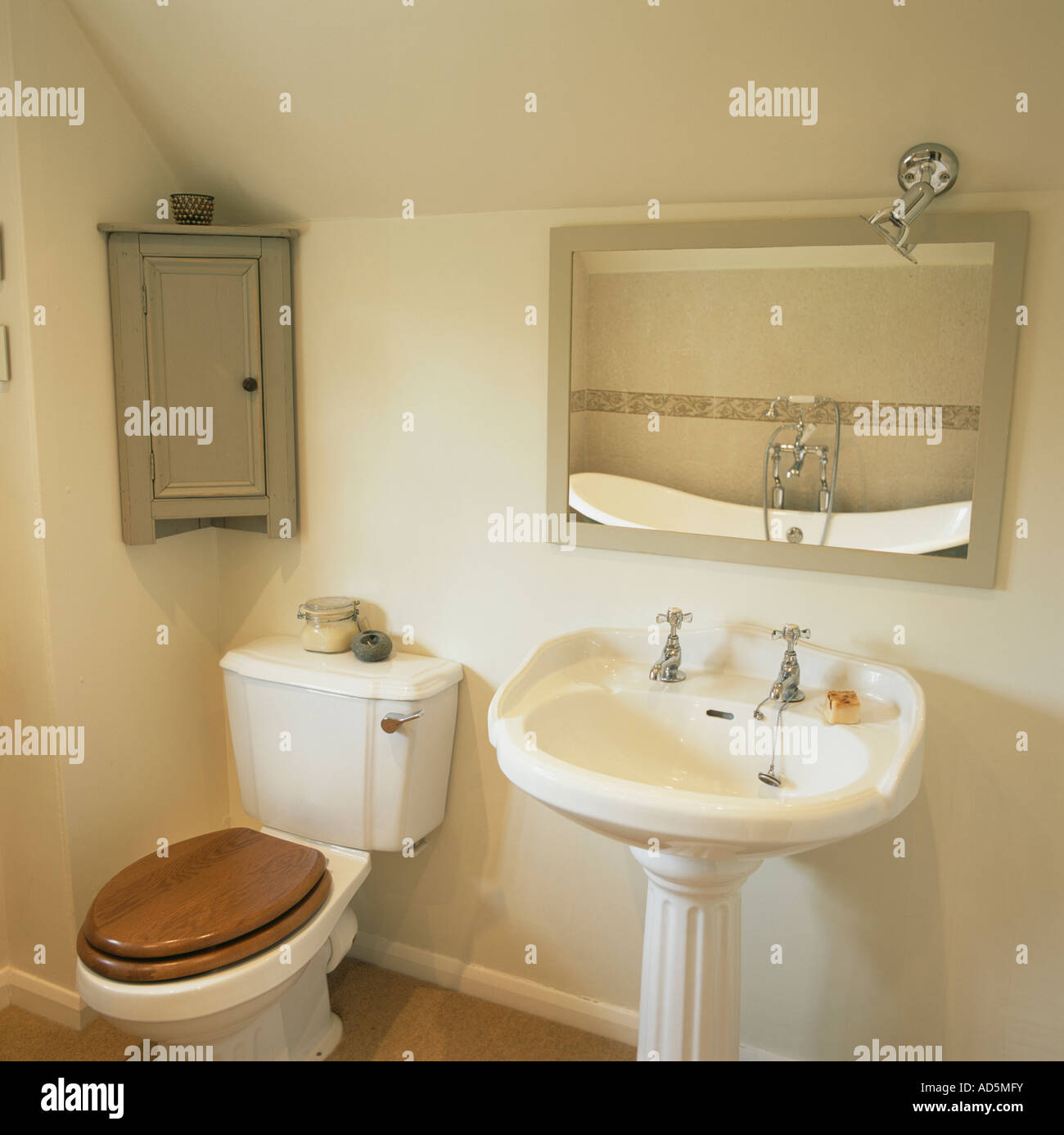 Toilet And Pedestal Basin Below Mirror In Traditional Cream Bathroom Stock Photo Alamy