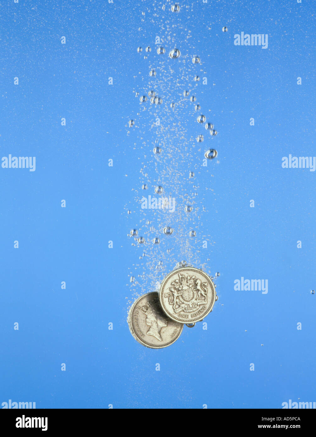 Pound coins sinking Stock Photo