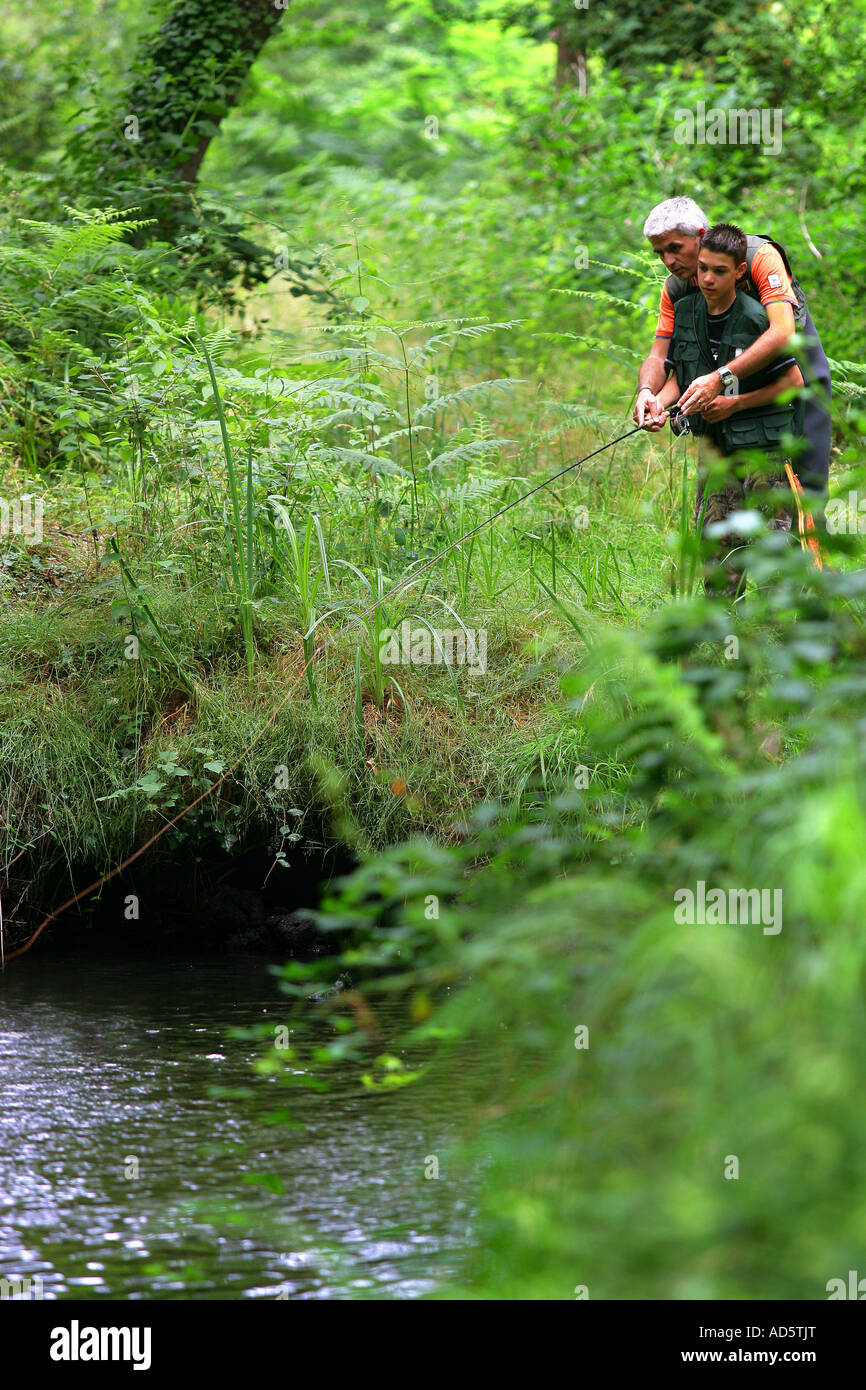 Man teaching a boy how to fish Stock Photo - Alamy