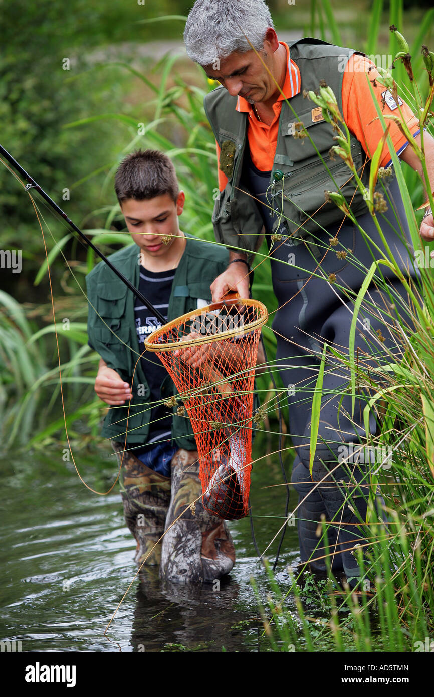 Illustration of Kids Catching Fish Using Net in a Stream or Wetland Stock  Photo - Alamy