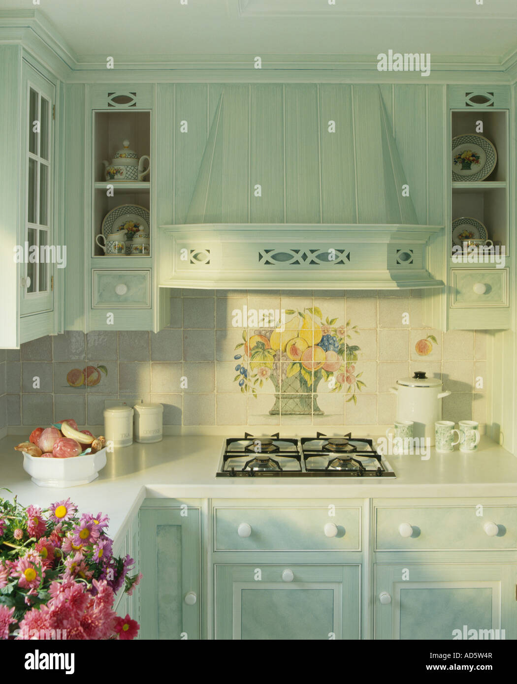 Corner Of Pastel Turquoise Kitchen With Floral Tiles Above Built