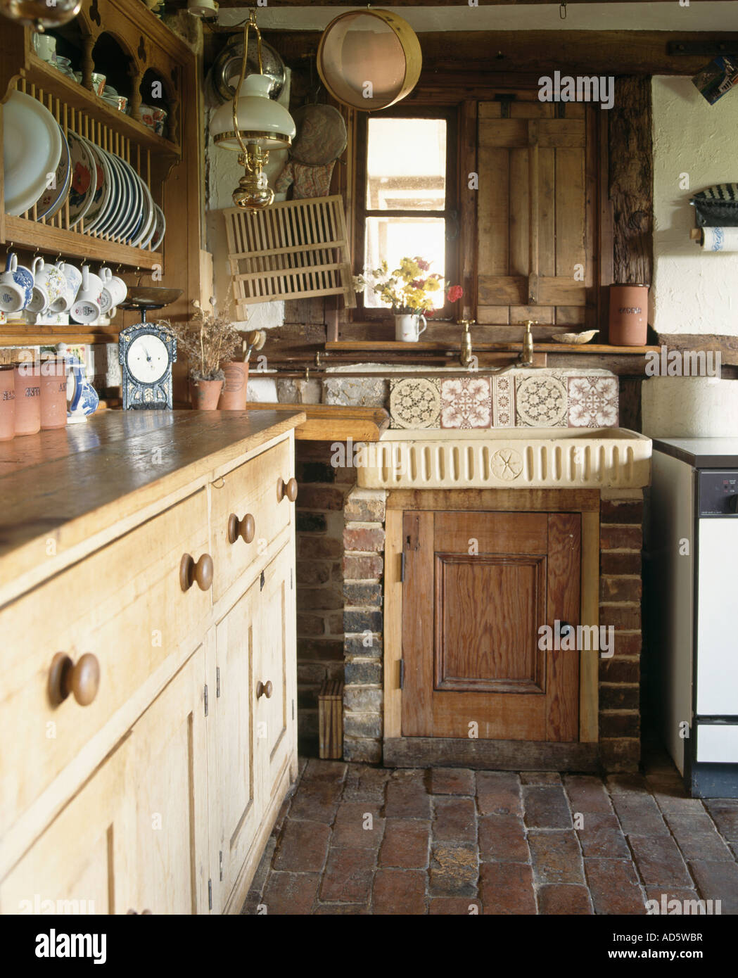 Earthenware Sink And Antique Pine Dresser In Small Cottage Kitchen
