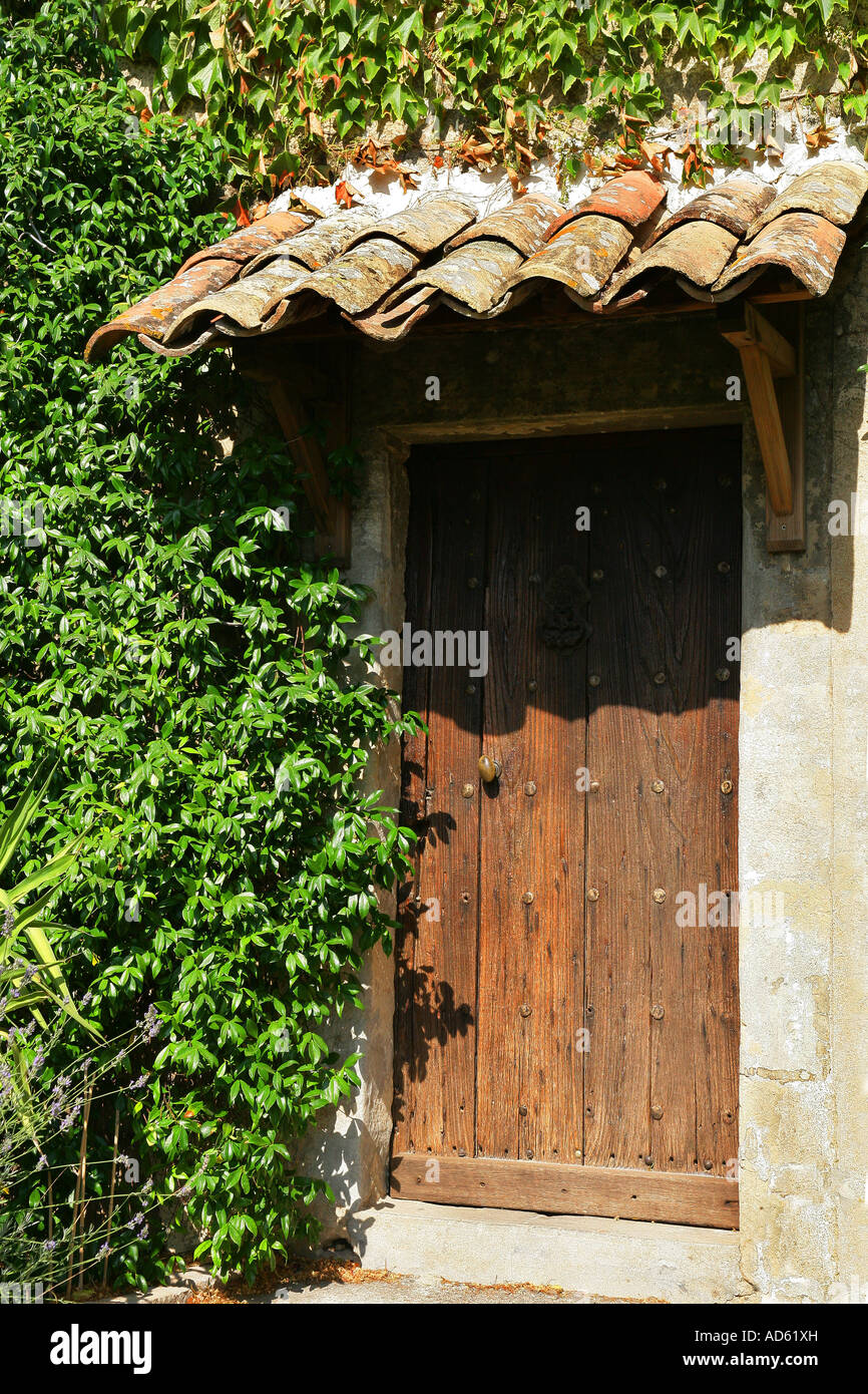 Climbing plants on walls and wooden entrance door Stock Photo