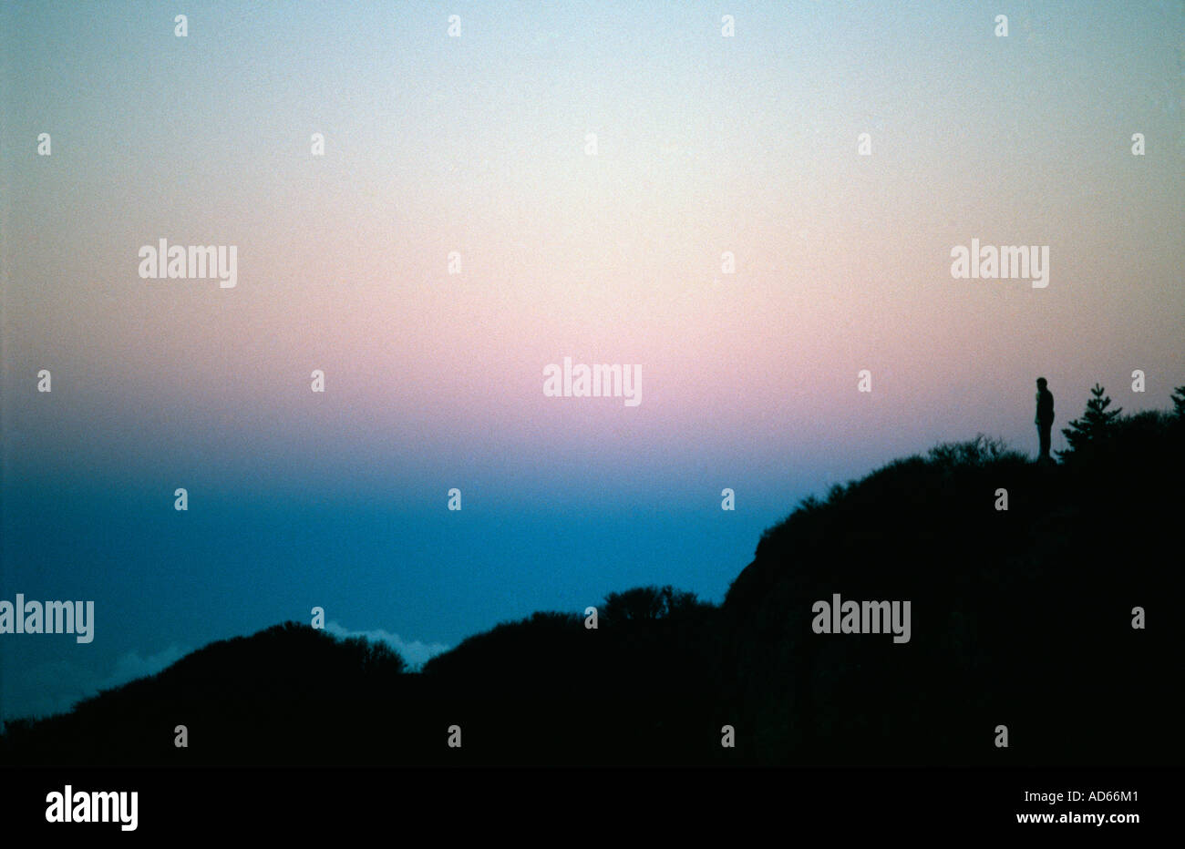 Silhouette of a trekker looking at the sunset in the Himalayas Stock Photo