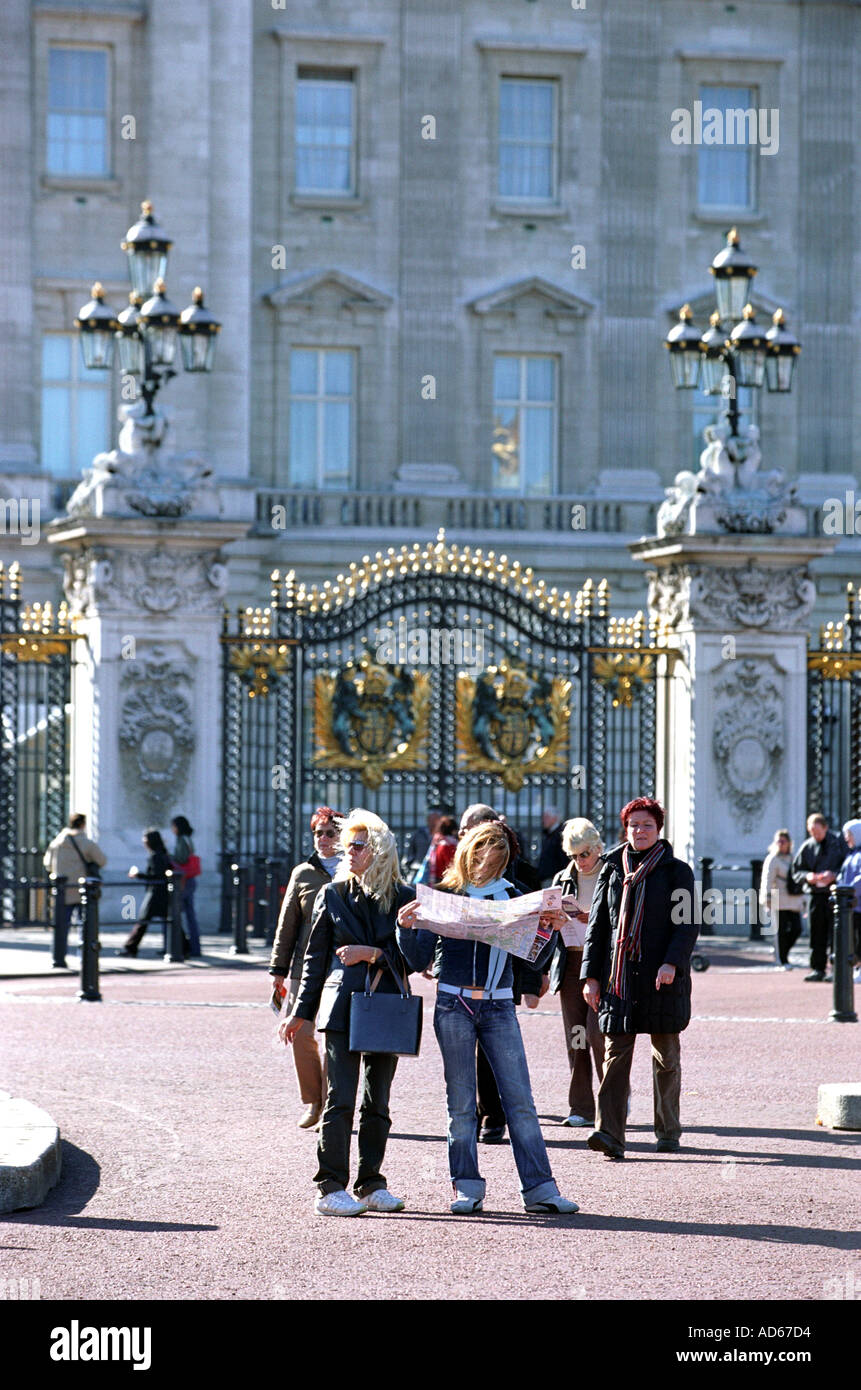 Tourists look at a map outside Buckingham Palace London Britain UK Stock Photo