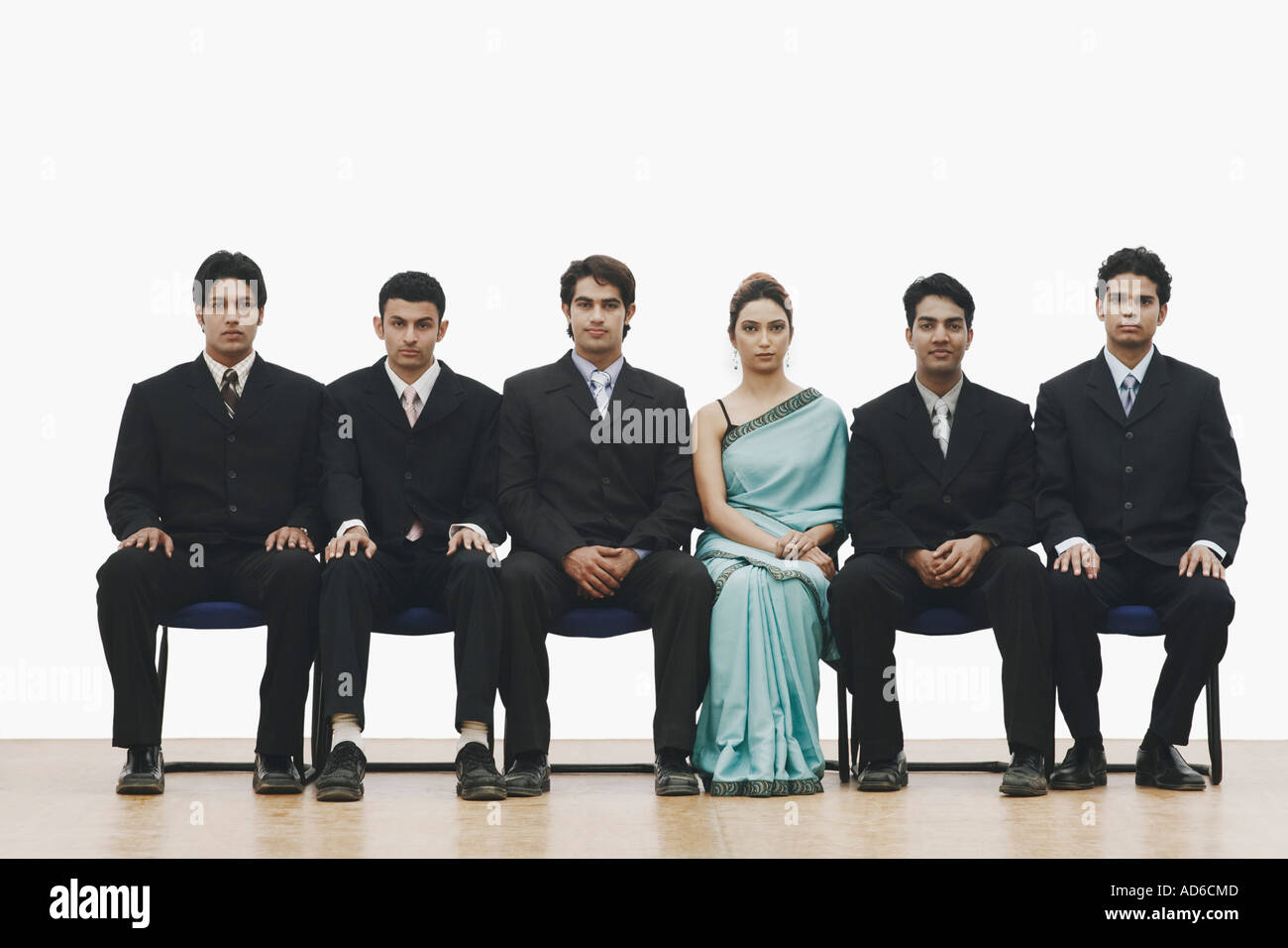 Portrait of a young woman sitting between five young men Stock Photo
