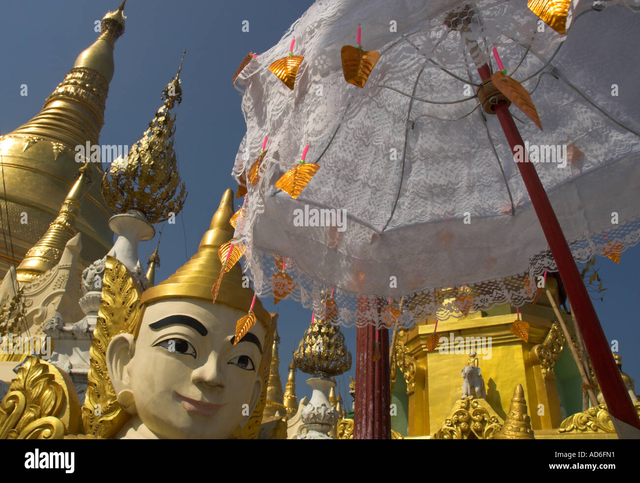 Myanmar Burma Yangon Shwedagon Paya mystical figure white umbrella and golden stupas Stock Photo