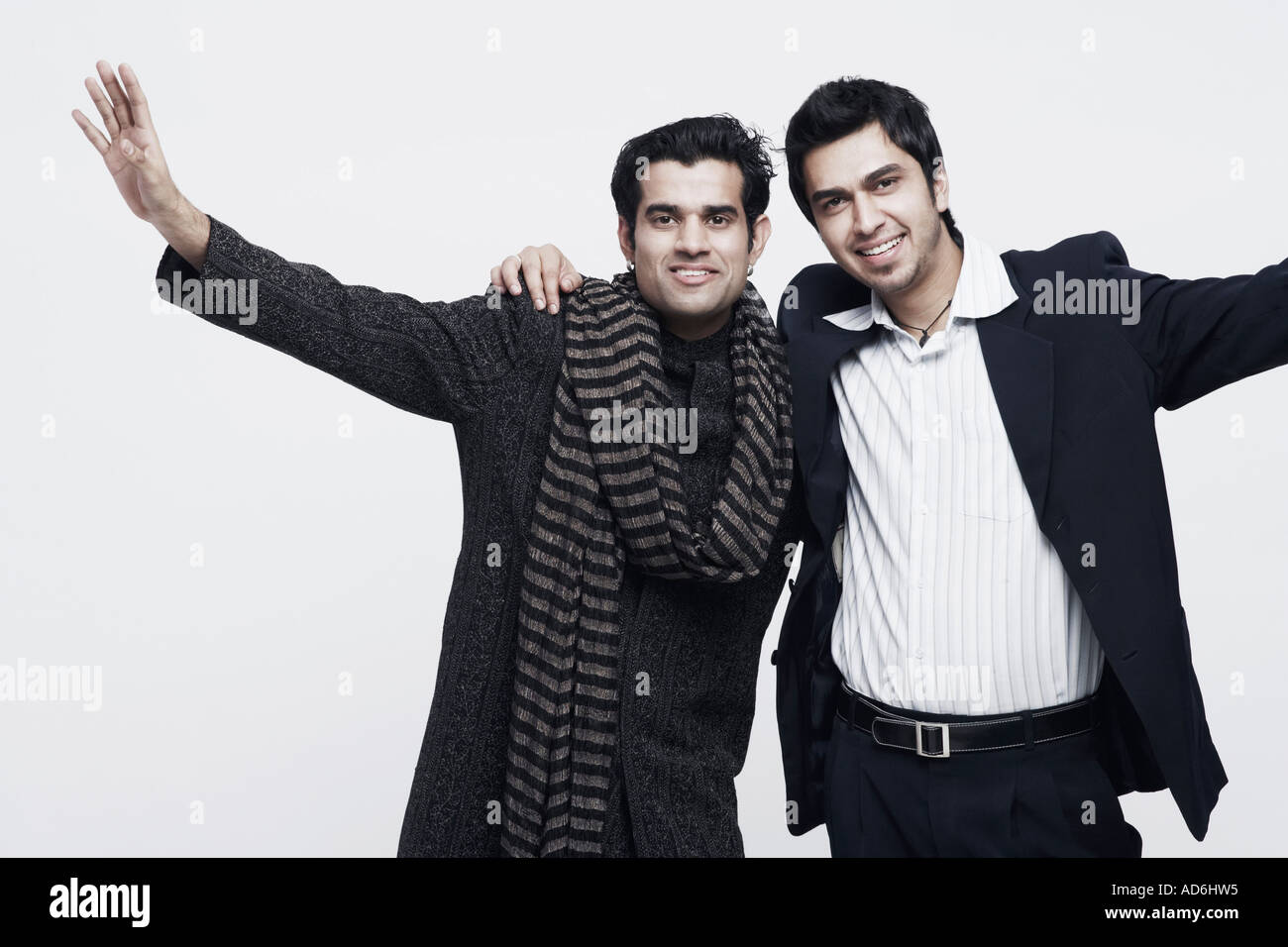 Portrait of two young men standing with their arms around each other ...