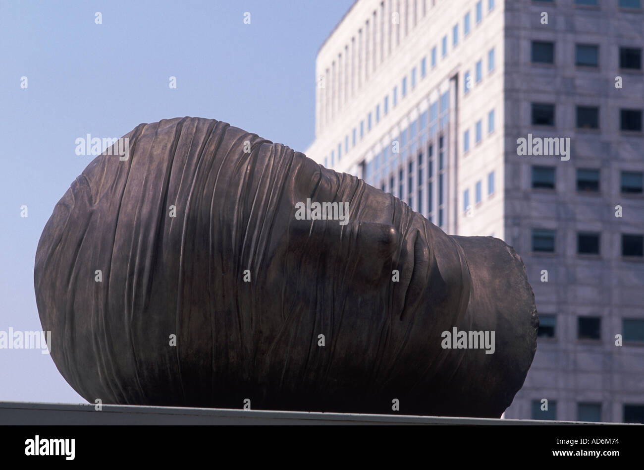 Large reclining head in open public space at Canary Wharf, London Docklands. Sculpture is by Igor Mitoraj. Stock Photo