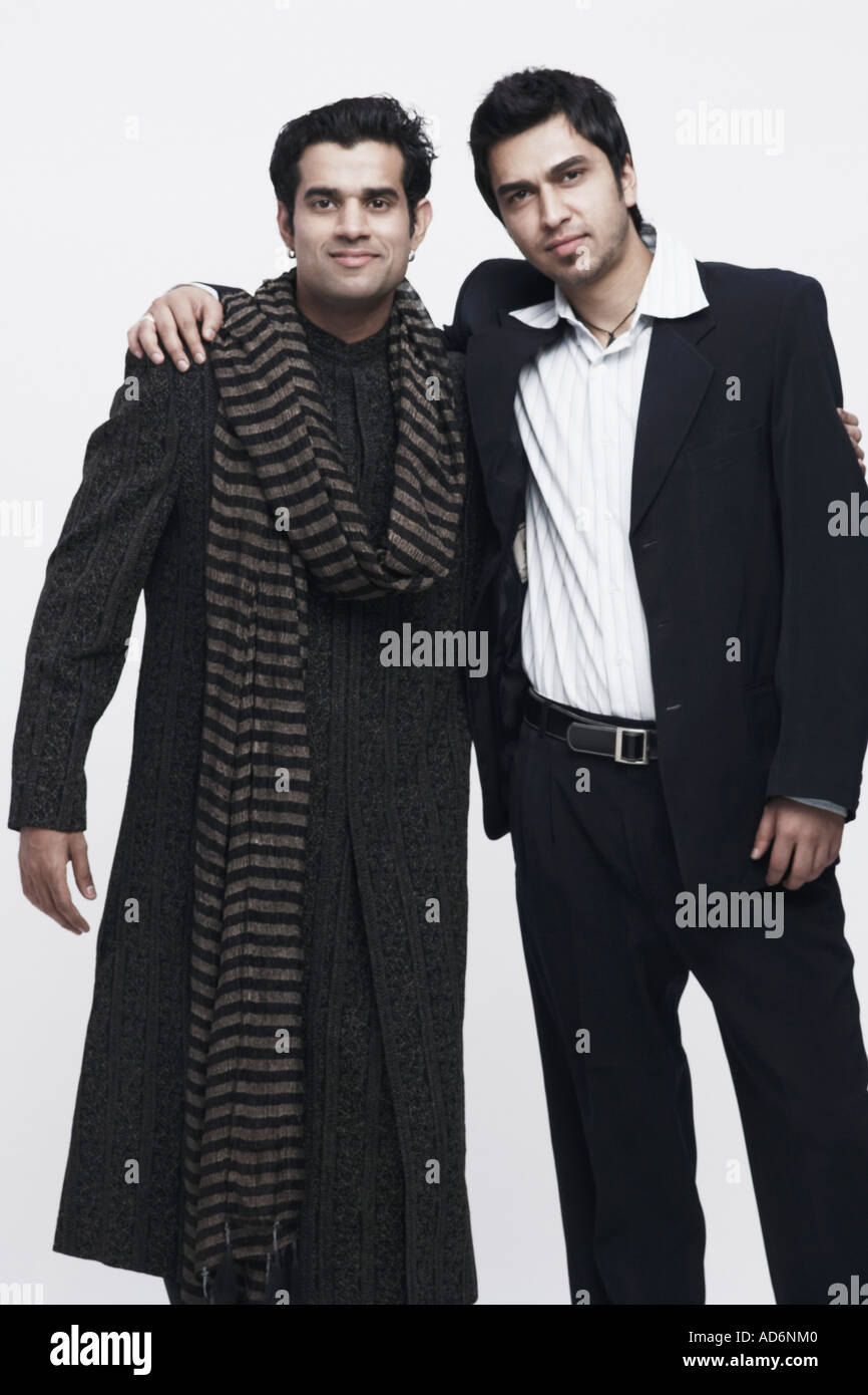 Portrait of two young men standing with their arms around each other ...