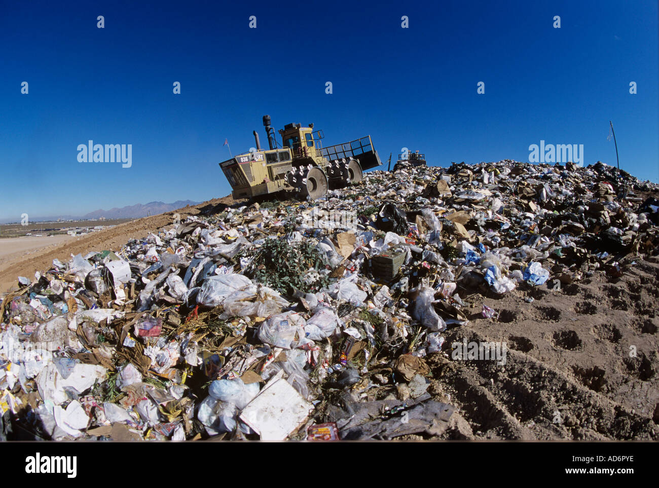 A large Cat plows trash at a landfill Stock Photo