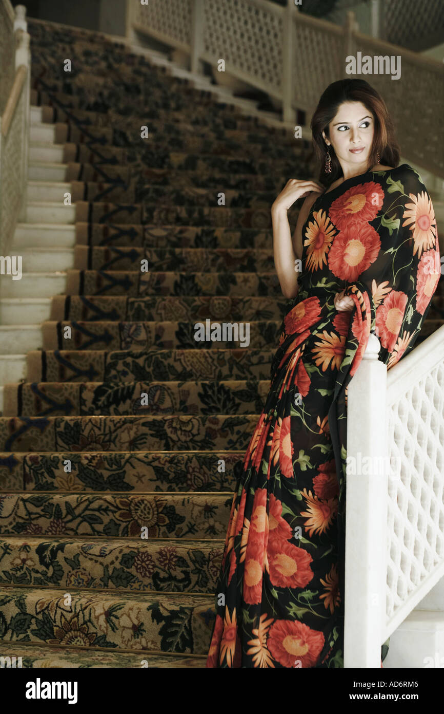 Young woman leaning against a hand rail Stock Photo
