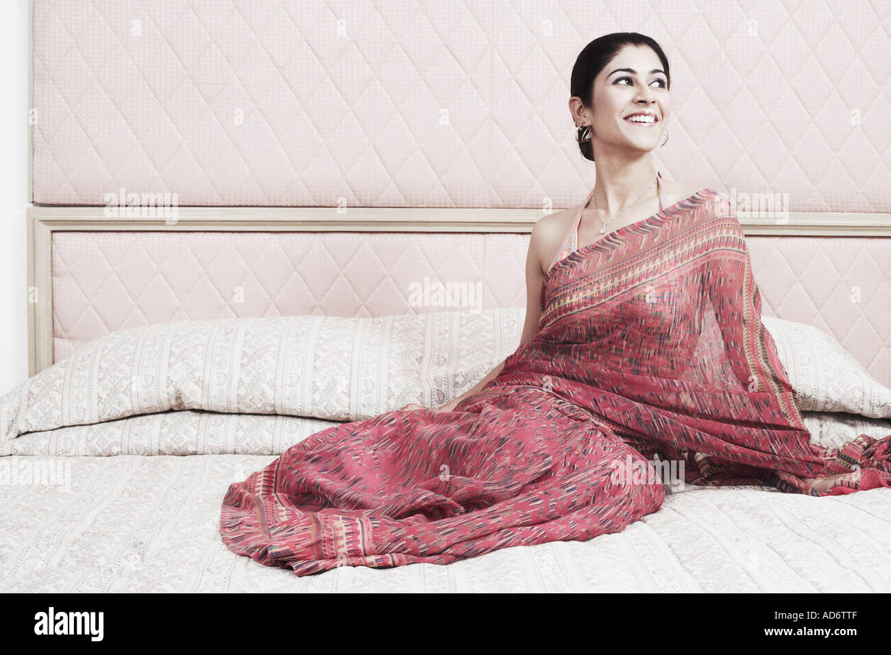 Young woman sitting on the bed Stock Photo