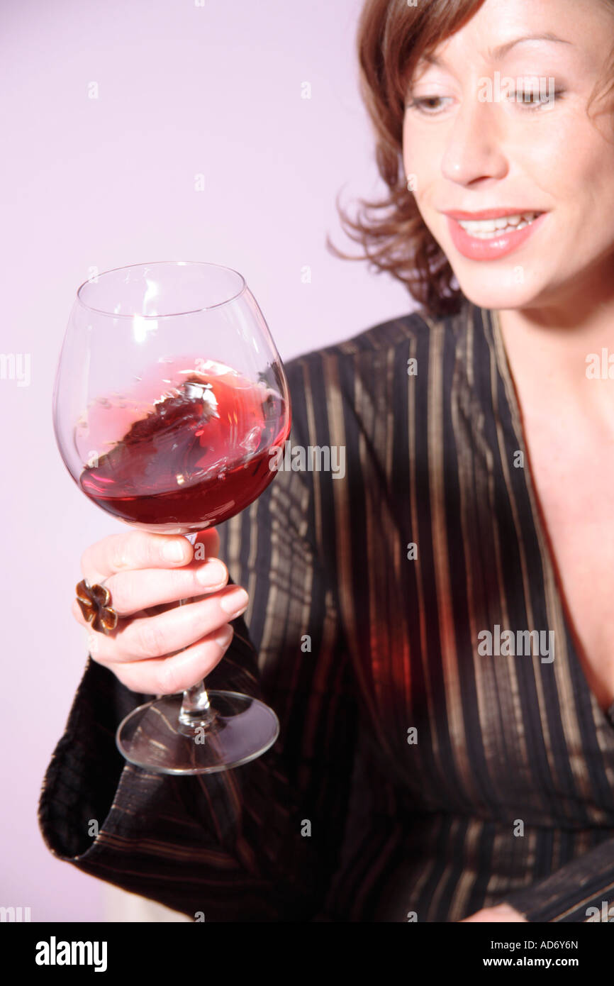 Woman looking at glass of red wine Stock Photo - Alamy