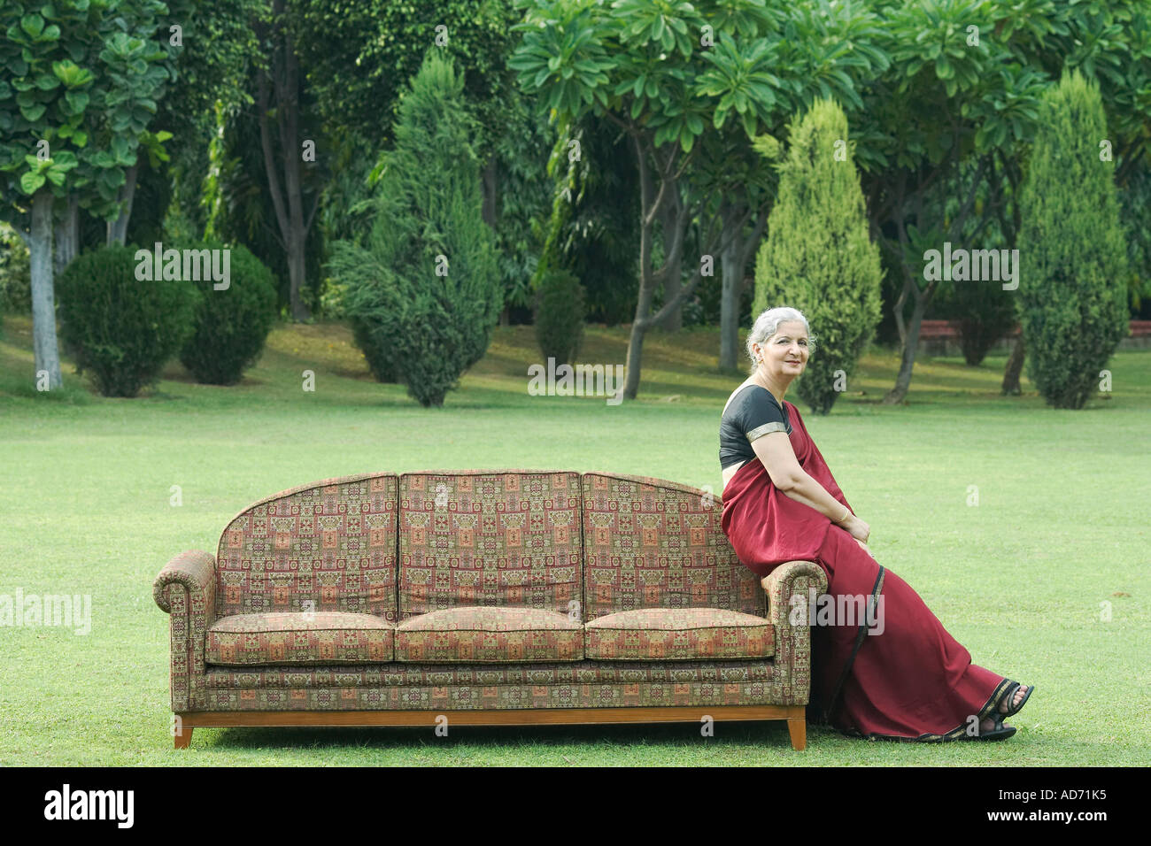 Side profile of a mature woman sitting on a couch outdoors Stock Photo