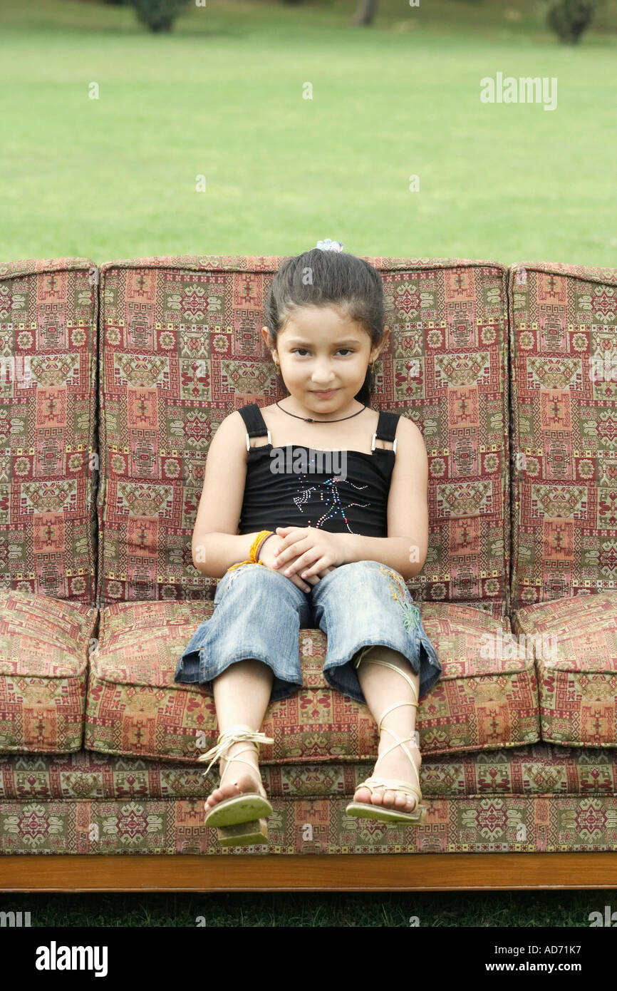 Portrait of a girl sitting on a couch outdoors Stock Photo - Alamy
