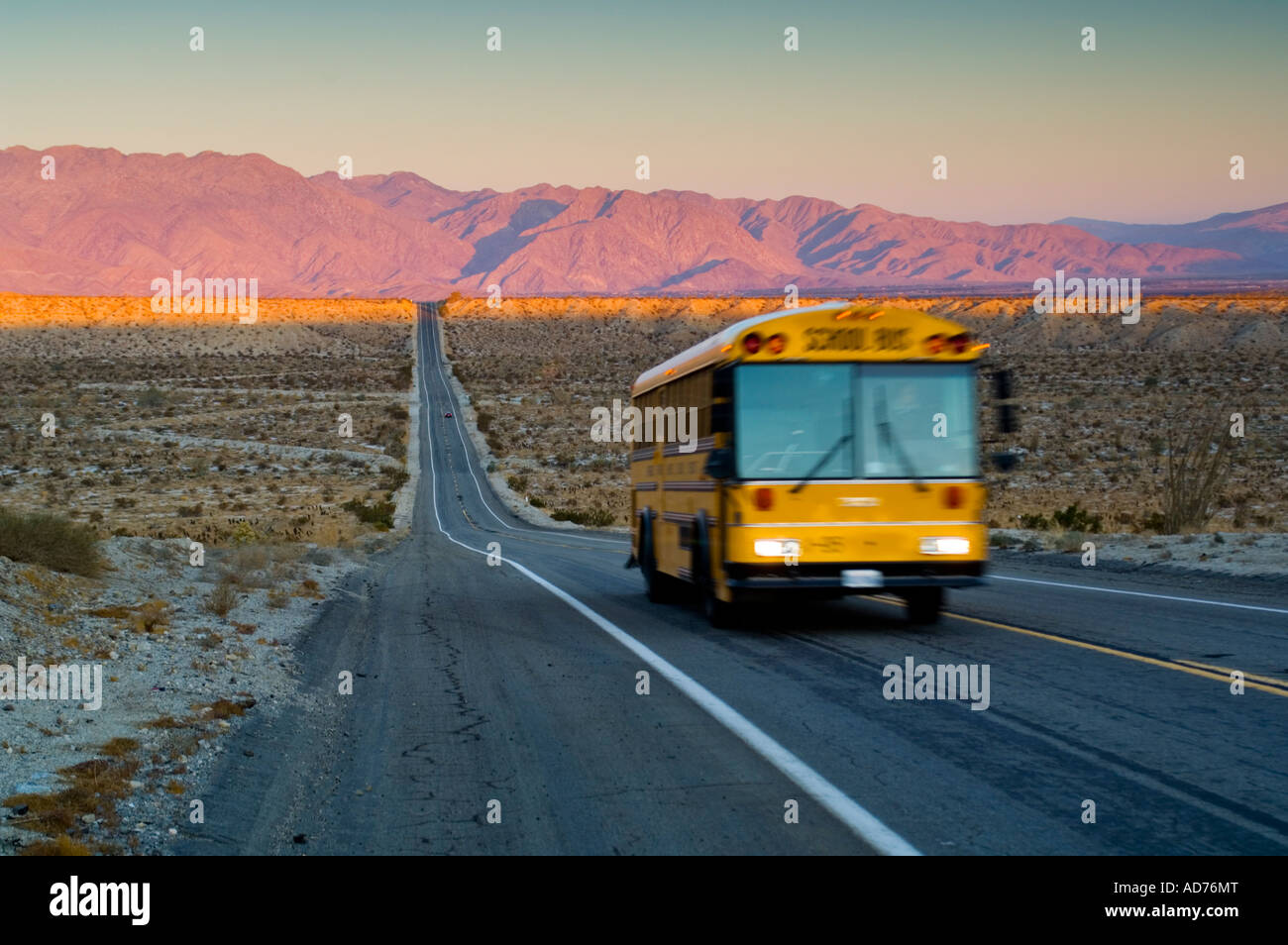 School bus on long straight two lane desert road at sunrise Anza Borrego Desert State Park San
