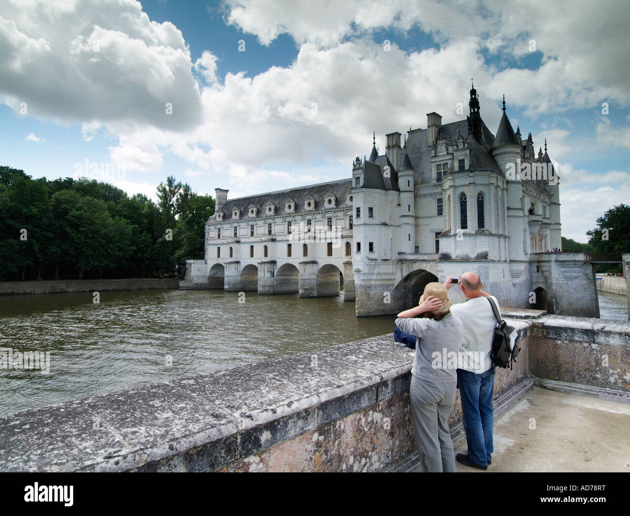 Older couple visiting the famous chateau de Chenonceau castle that is built on a bridge over the river Cher Stock Photo