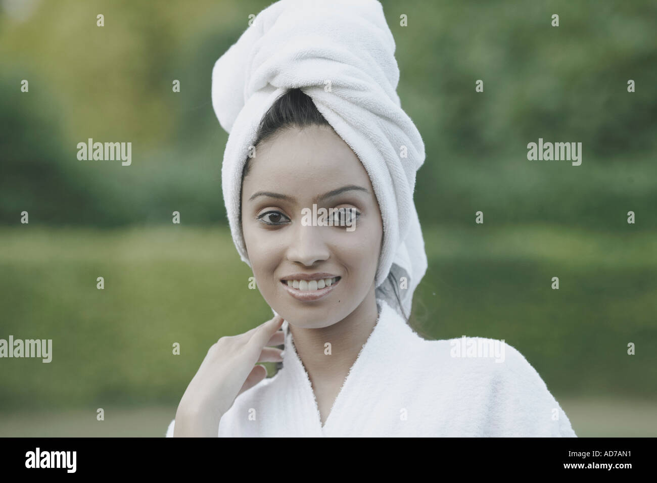 Portrait of a teenage girl smiling with a towel wrapped around her head ...