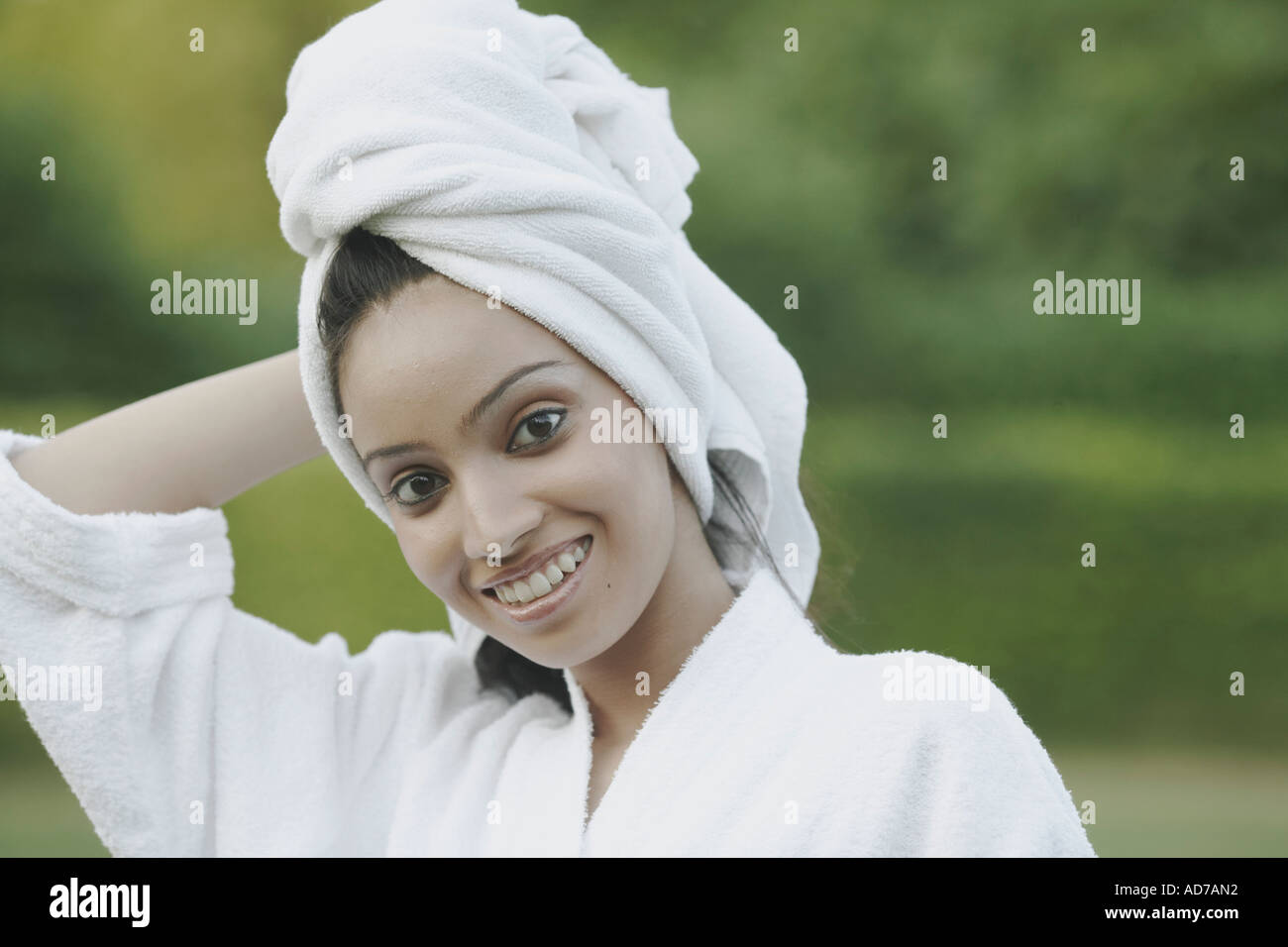 Portrait of a teenage girl smiling with a towel wrapped around her head ...