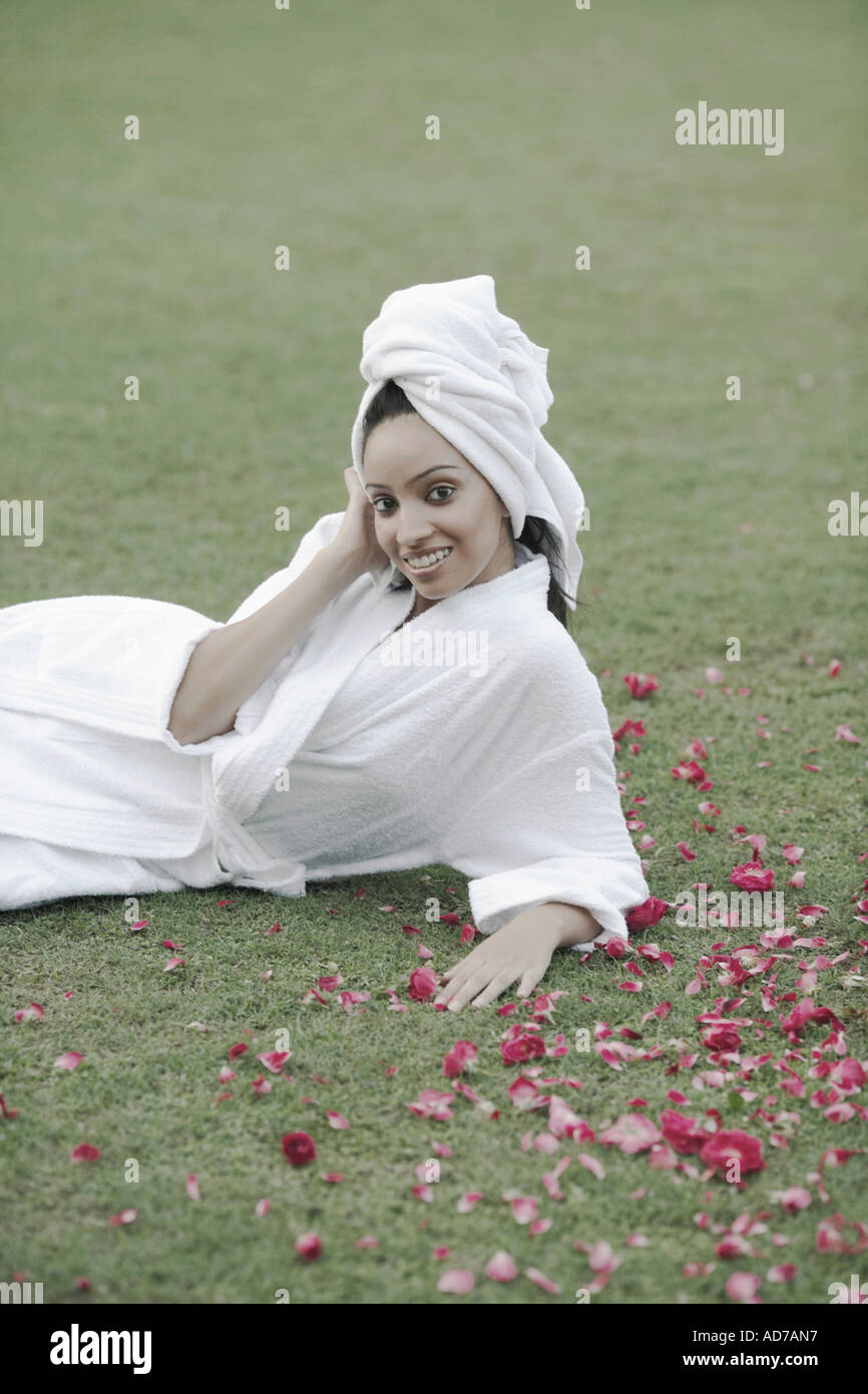 Portrait of a teenage girl in a bathrobe lying on the grass Stock Photo