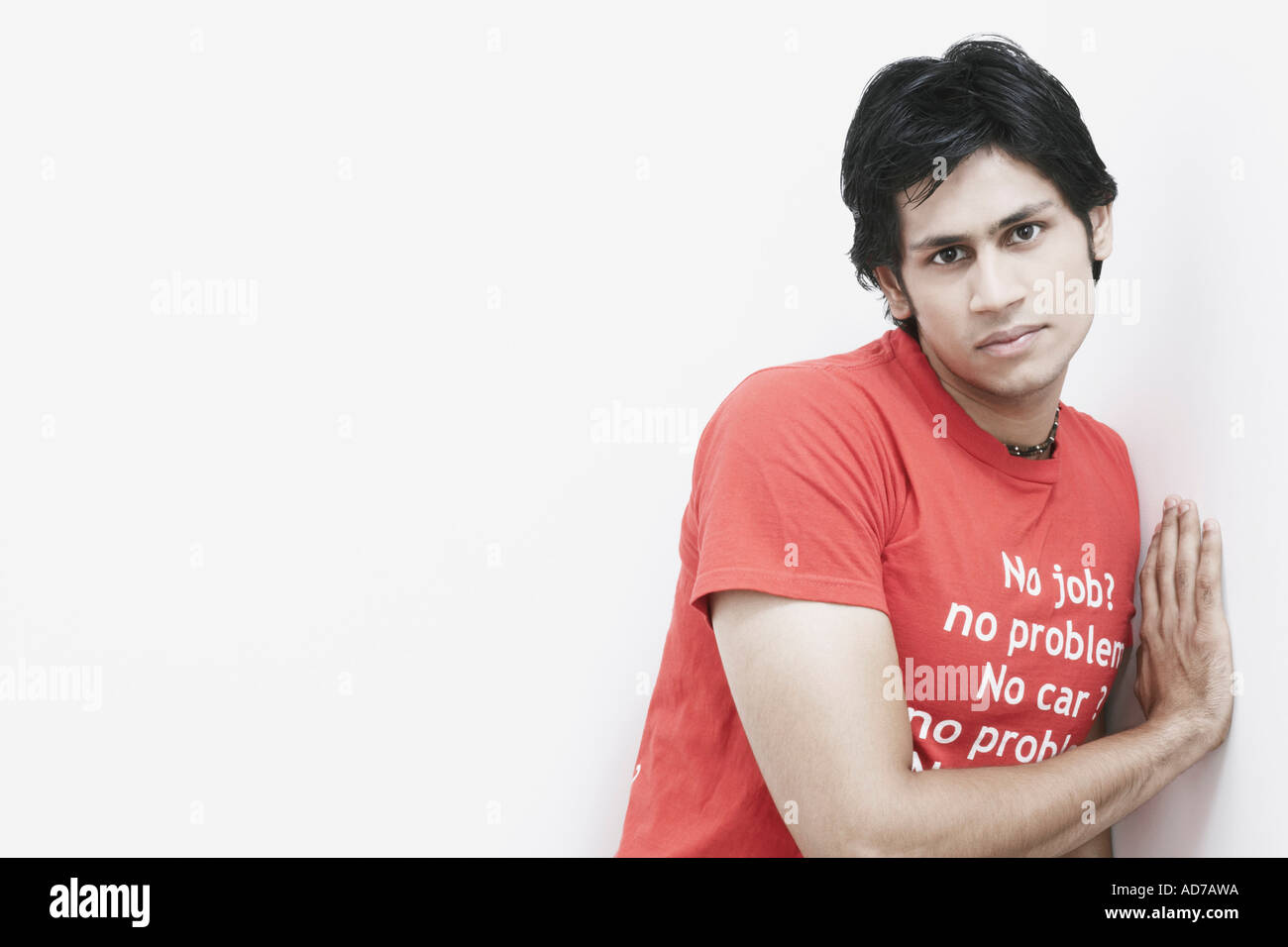 Portrait of a young man leaning against a wall Stock Photo - Alamy