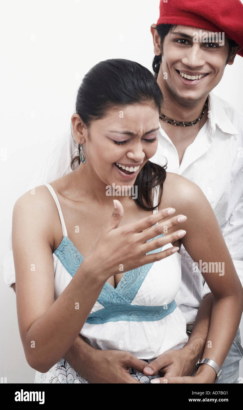Portrait of a young man embracing a young woman from behind Stock Photo ...