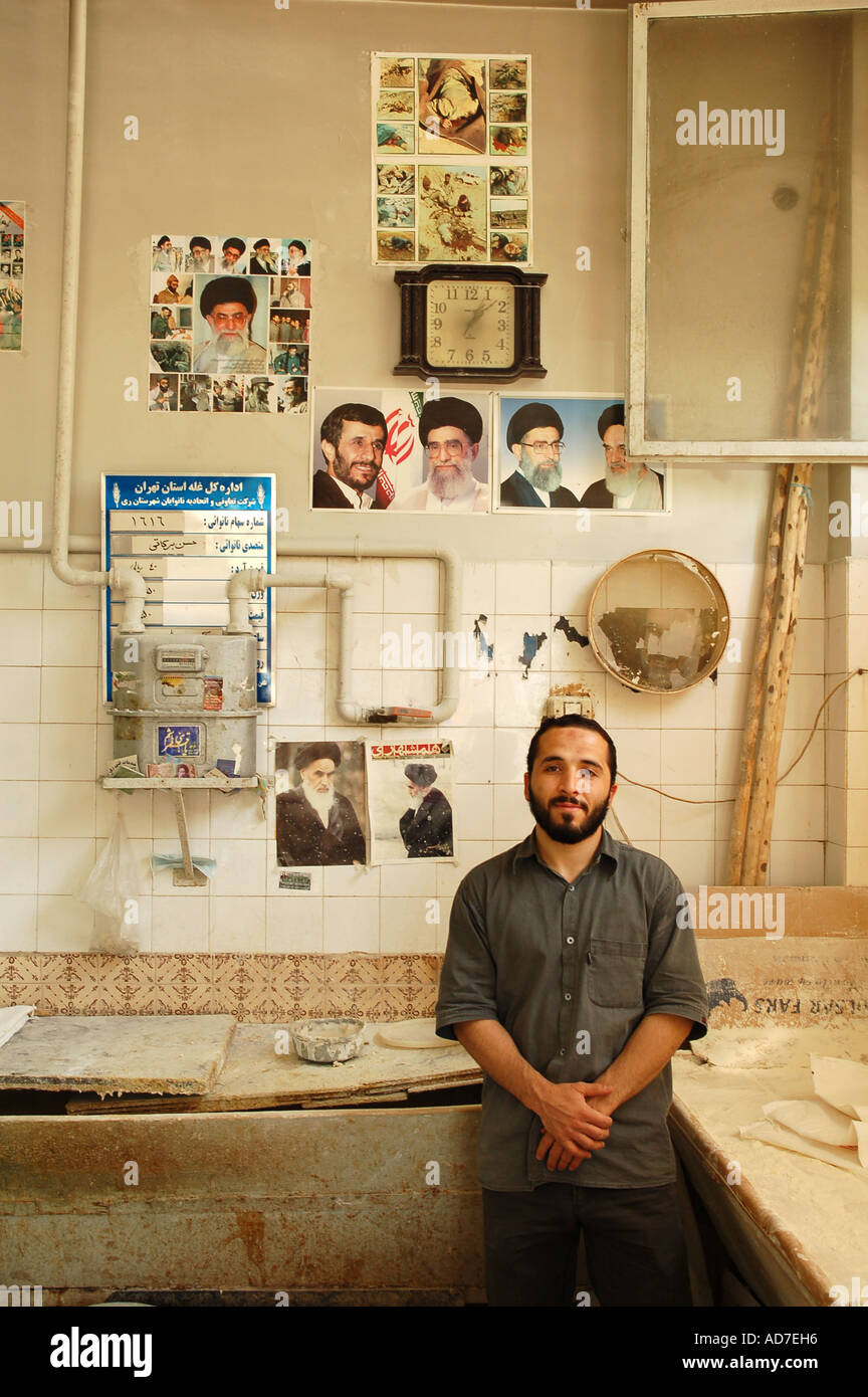 A man in a bakery with pictures of Iran and Iraq war, martyrs, Imam Khomeini and khamenei and the new president Ahmadinejad Stock Photo