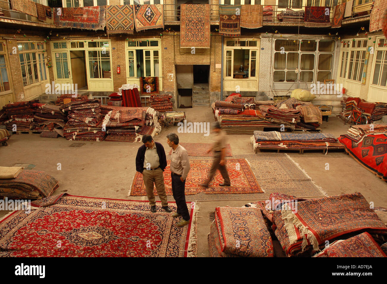 A seller and buyer talking about the price of a rug in a rug shop in Tehran Bazaar. Stock Photo
