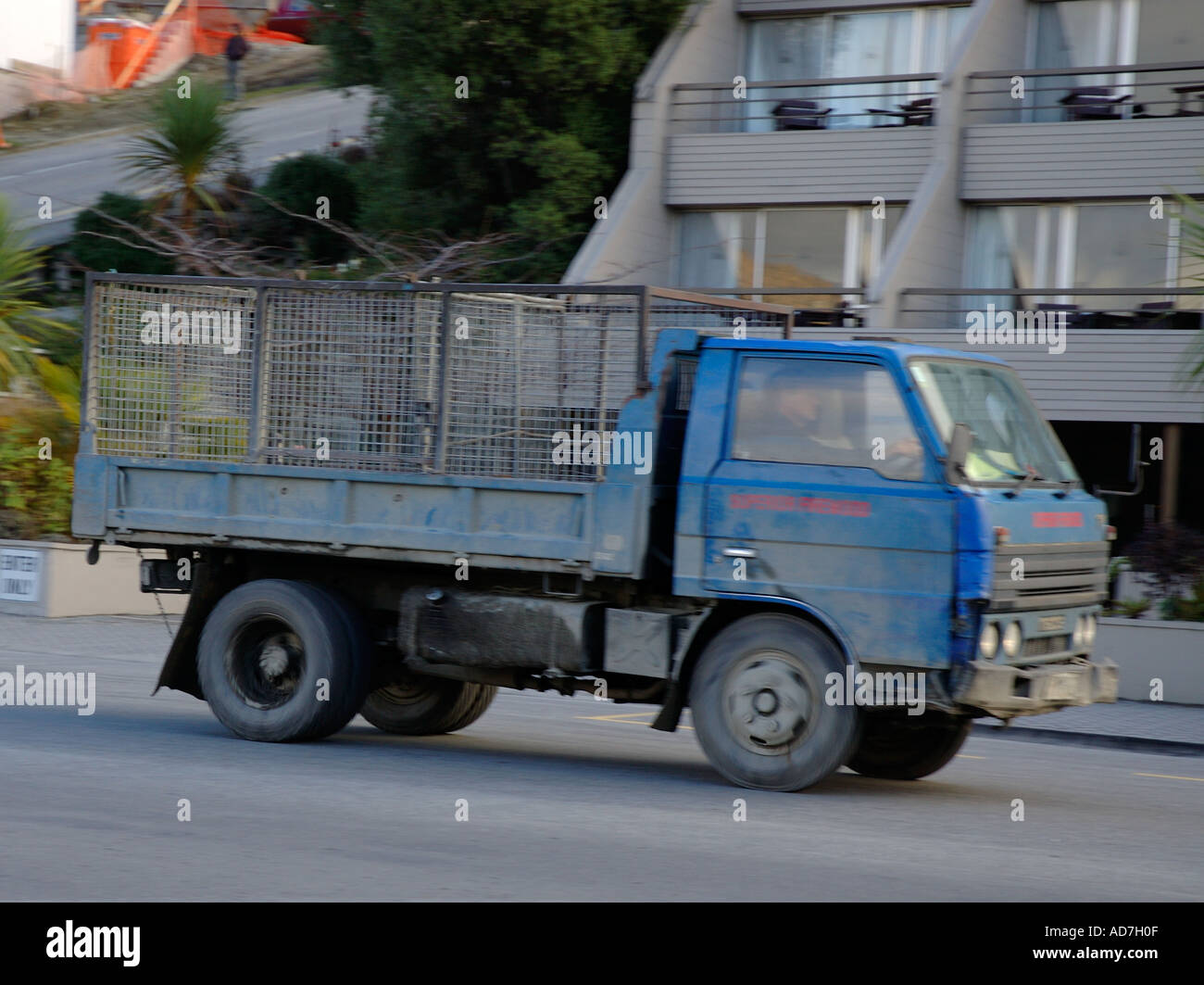 Small vehicle carrying goods in cage at rear Stock Photo - Alamy