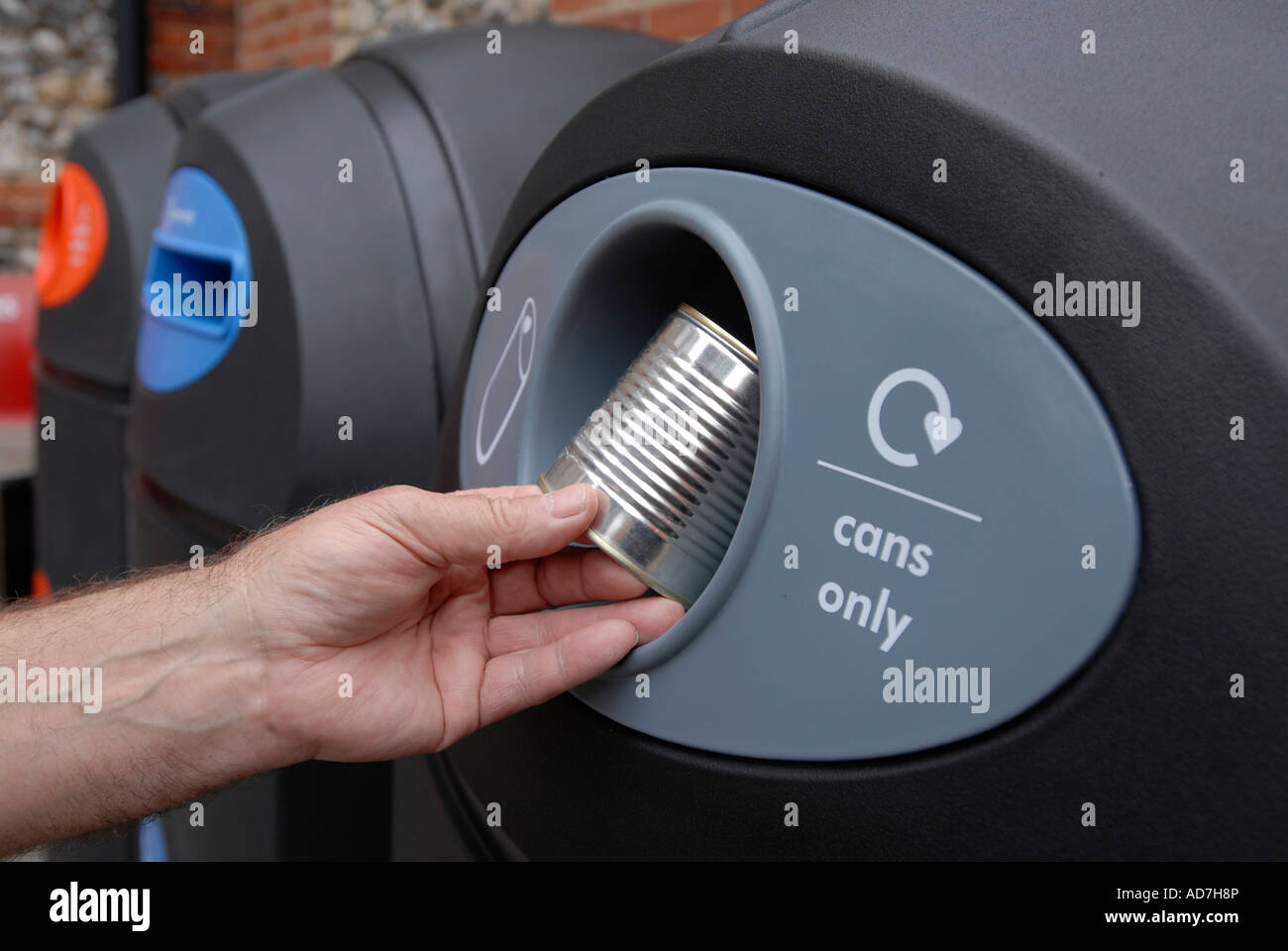 Man placing a tin can for recycling in a local authority recycling bin