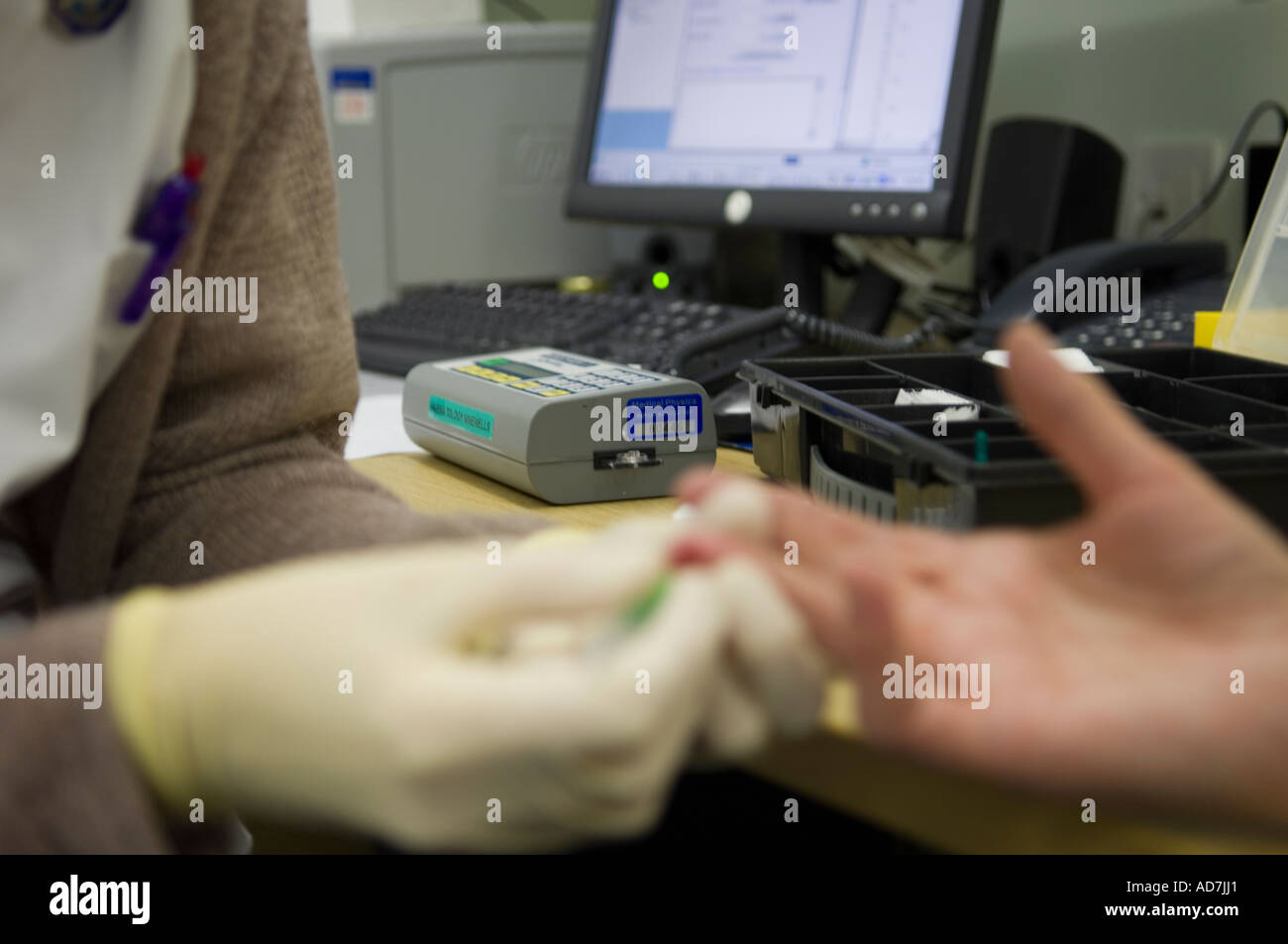 Nurse performing a finger prick blood test on a patient Stock Photo Alamy