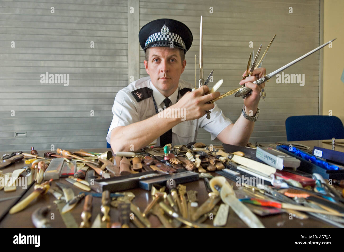 Scottish policeman showing a variety of knives handed in at police stations. Stock Photo
