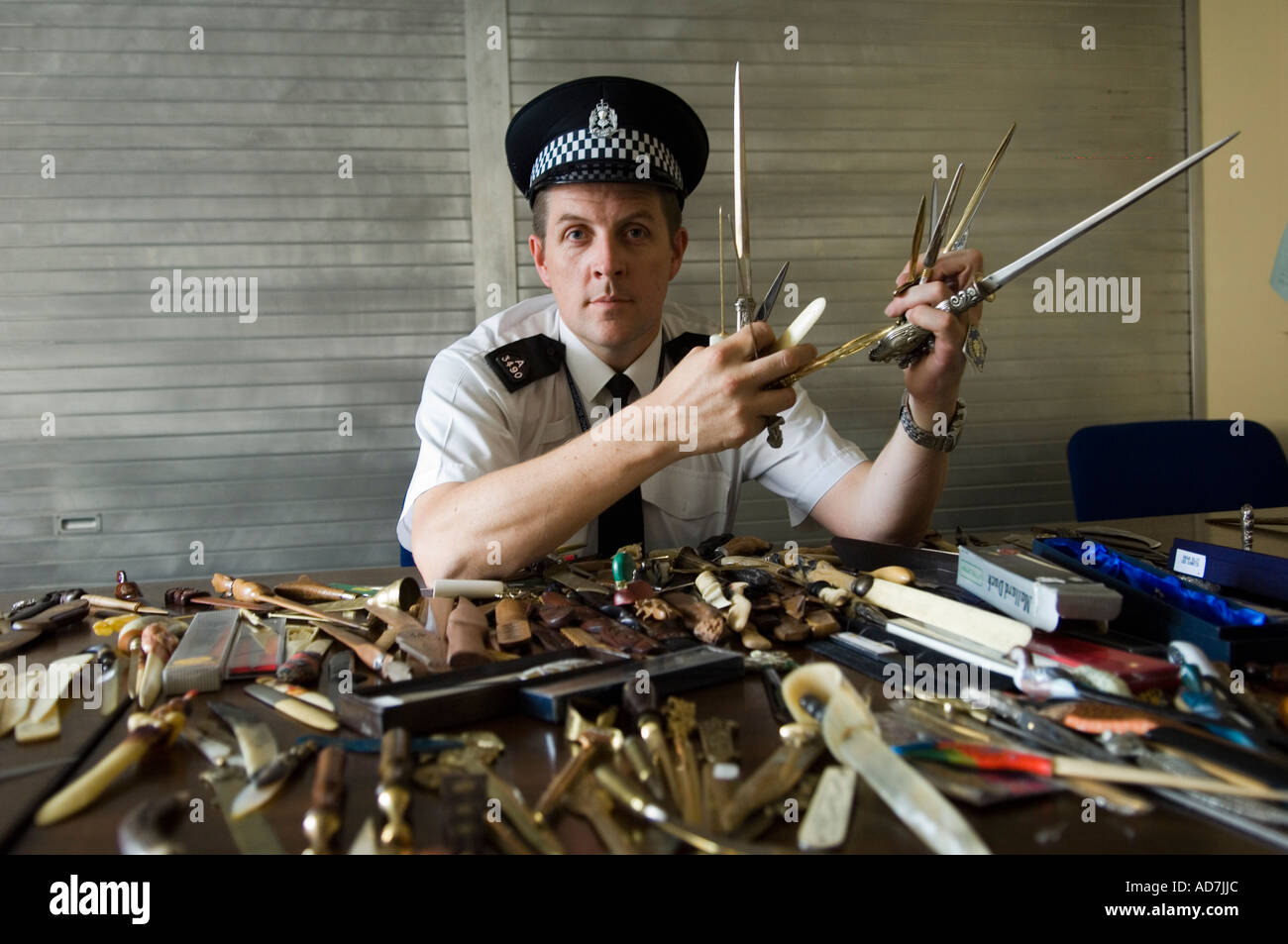 Scottish policeman showing  knives and other cutting weapons Stock Photo