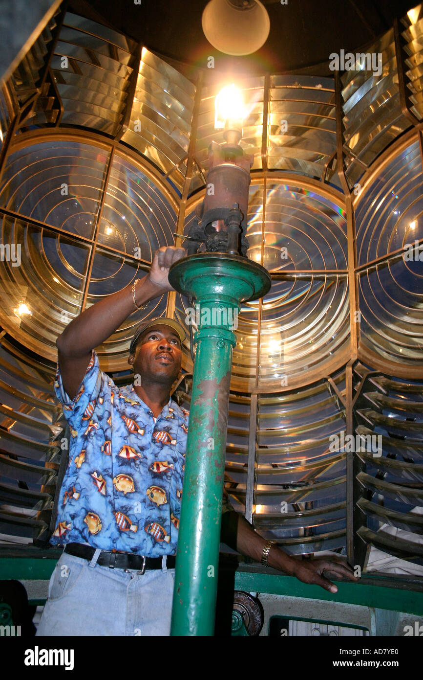 The mantle of the Hopetown lighthouse finally lights casting a warm glow over the Fresnel lens walled tip of the lighthouse Stock Photo