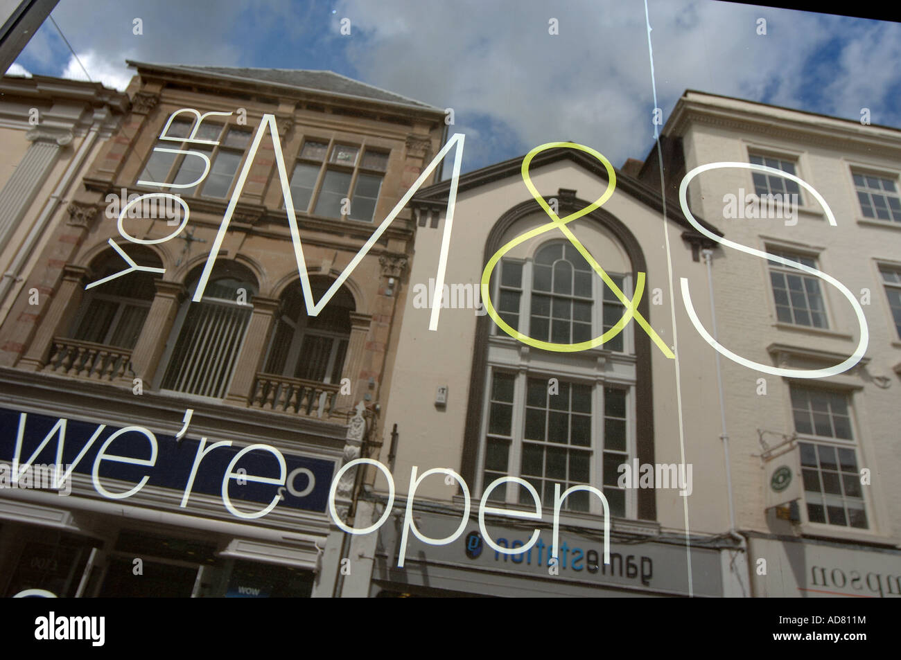 A Marks & Spencer sign on a window in Barnstaple, North Devon, with buildings reflected in the glass Stock Photo