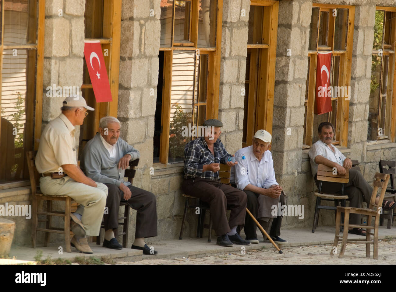 Elderly retired and unemployed Turkish men sitting in public square in village of Yesilyurt, western Turkey Stock Photo