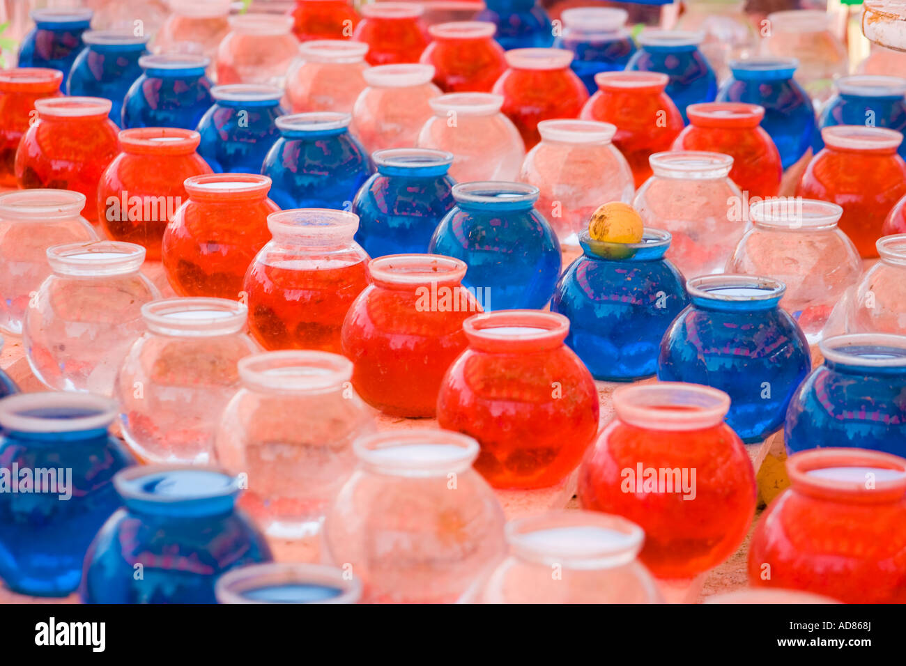 Striped rows of red white and blue glass bowls of water with a yellow ping  pong ball in one at a county fair game Stock Photo - Alamy
