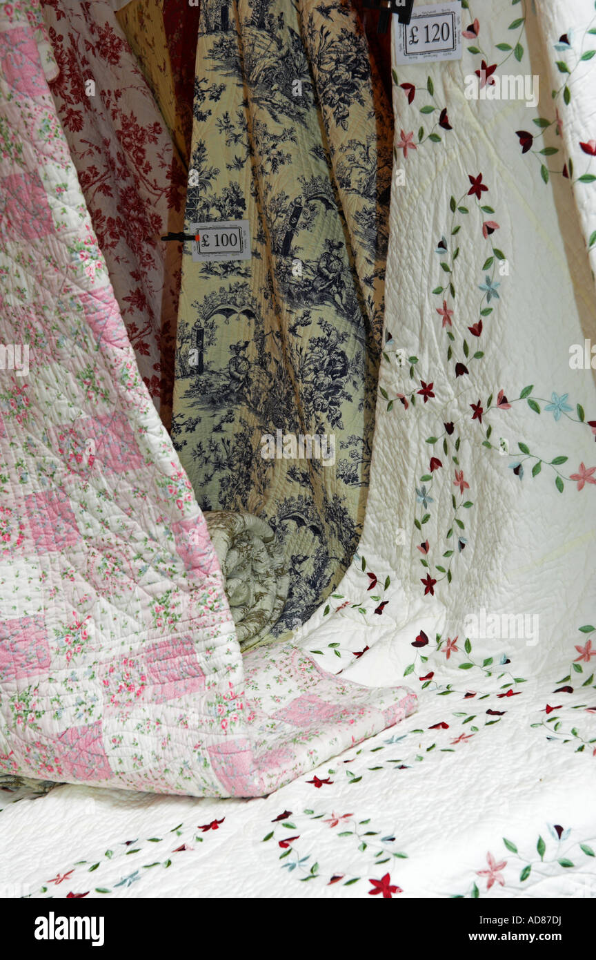 Hanging draped quilted bedspreads for sale Stock Photo