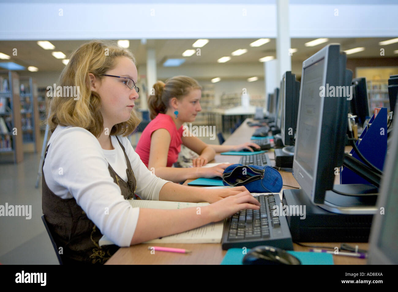 Teenage girls behind a computer in the library Stock Photo - Alamy