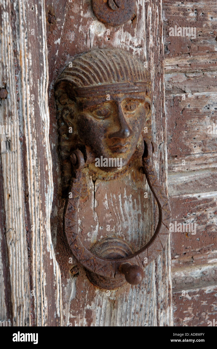 Rusty door knocker on a woodworm-eaten door in Apiranthos, Greece Stock Photo