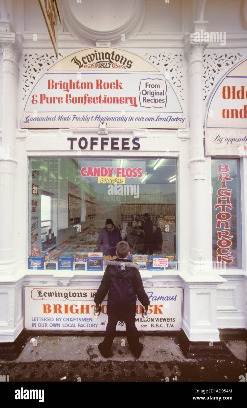 Small boy looking in the window of a confectionery shop in Brighton England which specialises in Brighton Rock candy 1980 Stock Photo