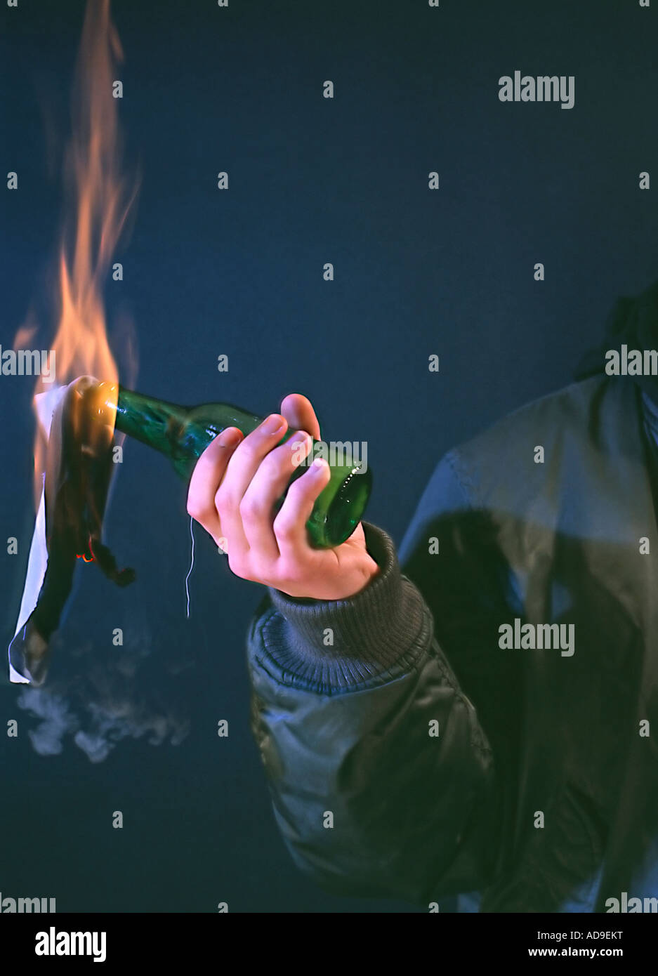 hand throwing a Molotwcoctail burning bottle radical person in black bomber jacket Stock Photo