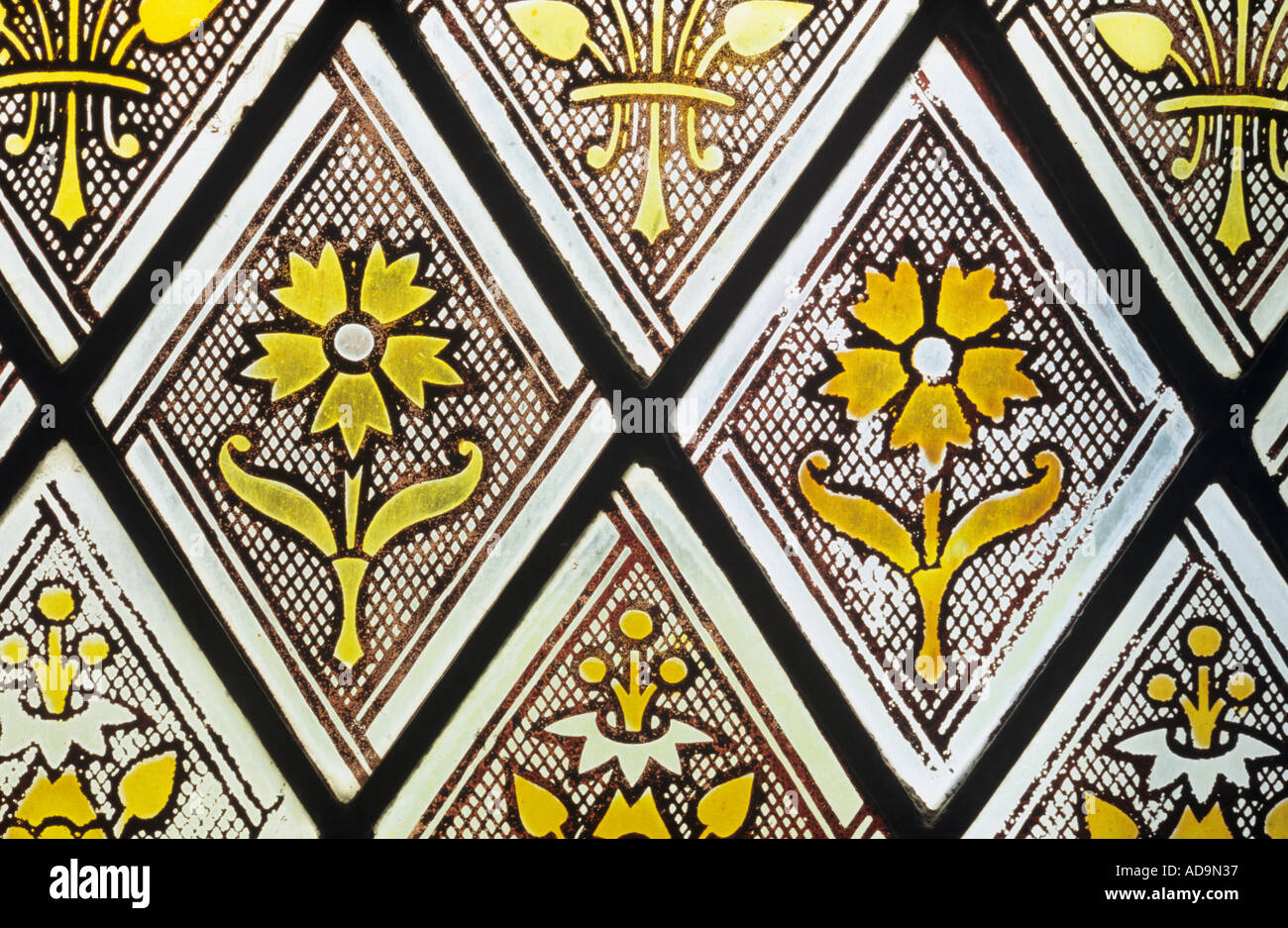 Close up of repeating flower icons in diamond shaped panes as used in Victorian stained glass windows Stock Photo