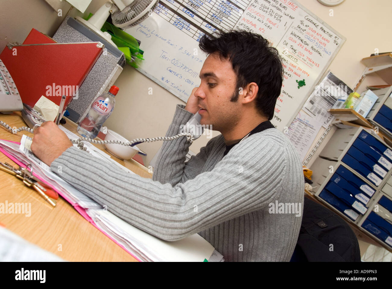 Mental Health Worker In Office Talking On Telephone At Psychiatric 