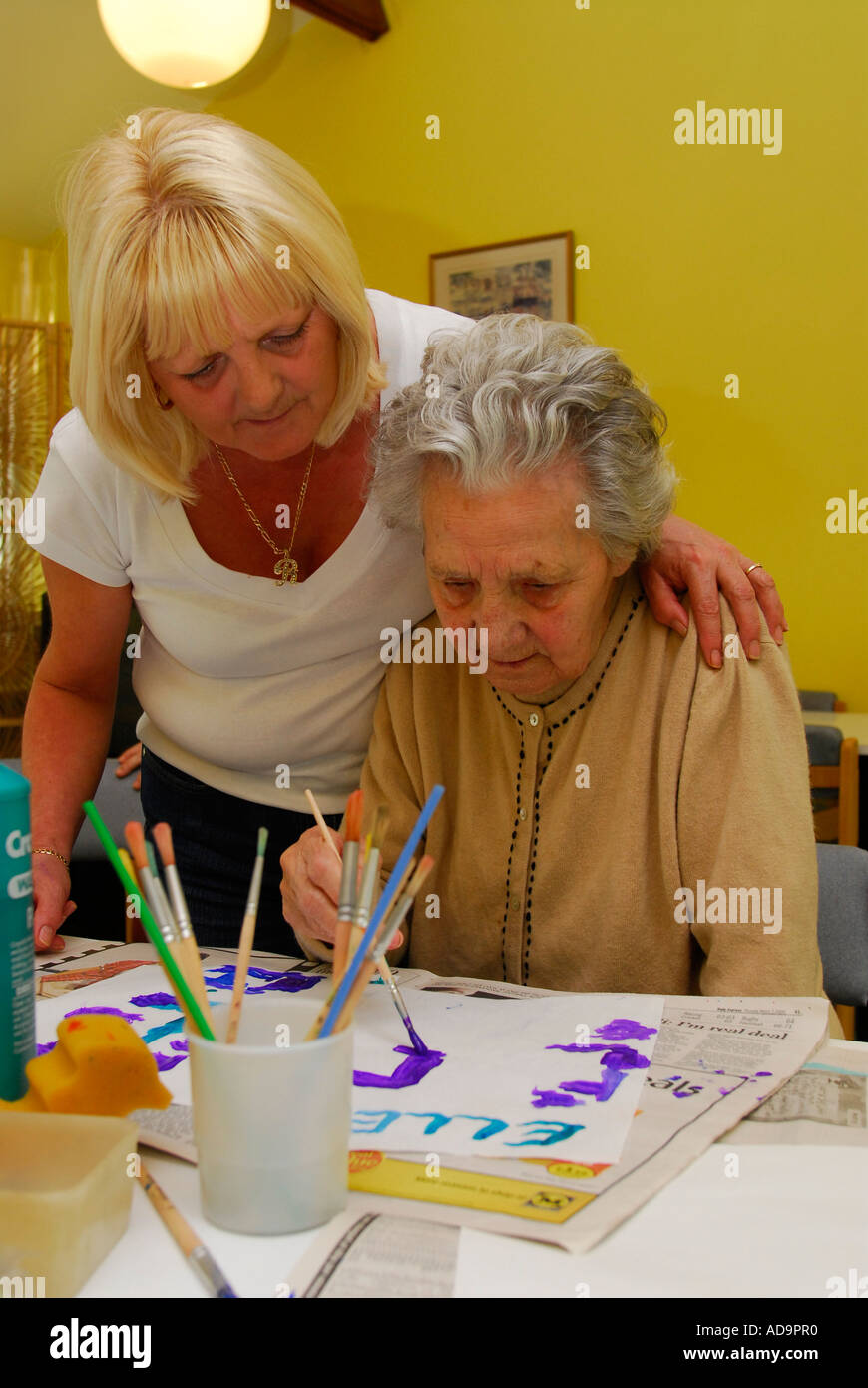 Elderly woman suffering from dementia in painting class in care home