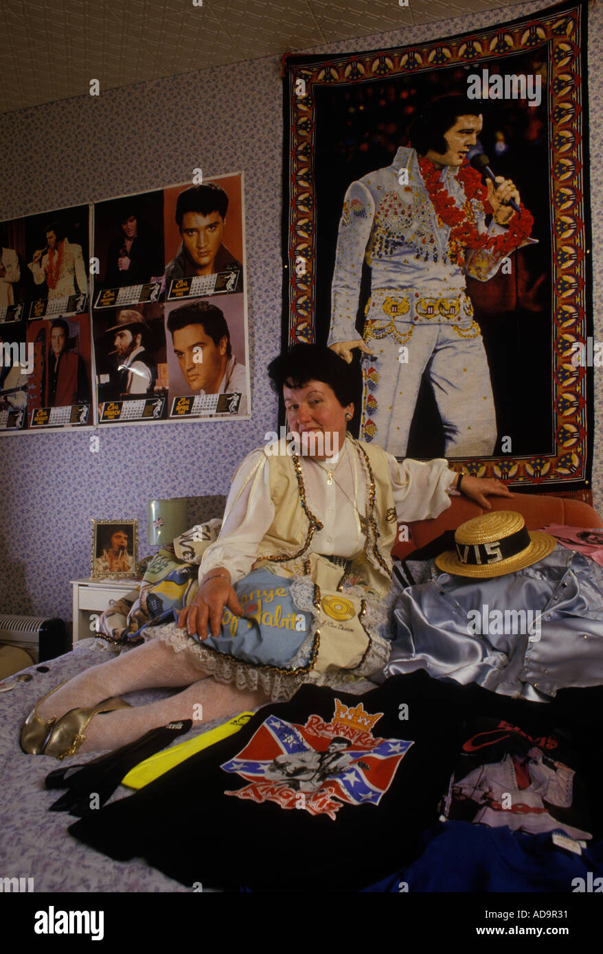 Elvis Presley fan with memorabilia and wearing an Elvis patterned dress and earrings. This is her tribute bedroom. 1990s 90s HOMER SYKES Stock Photo
